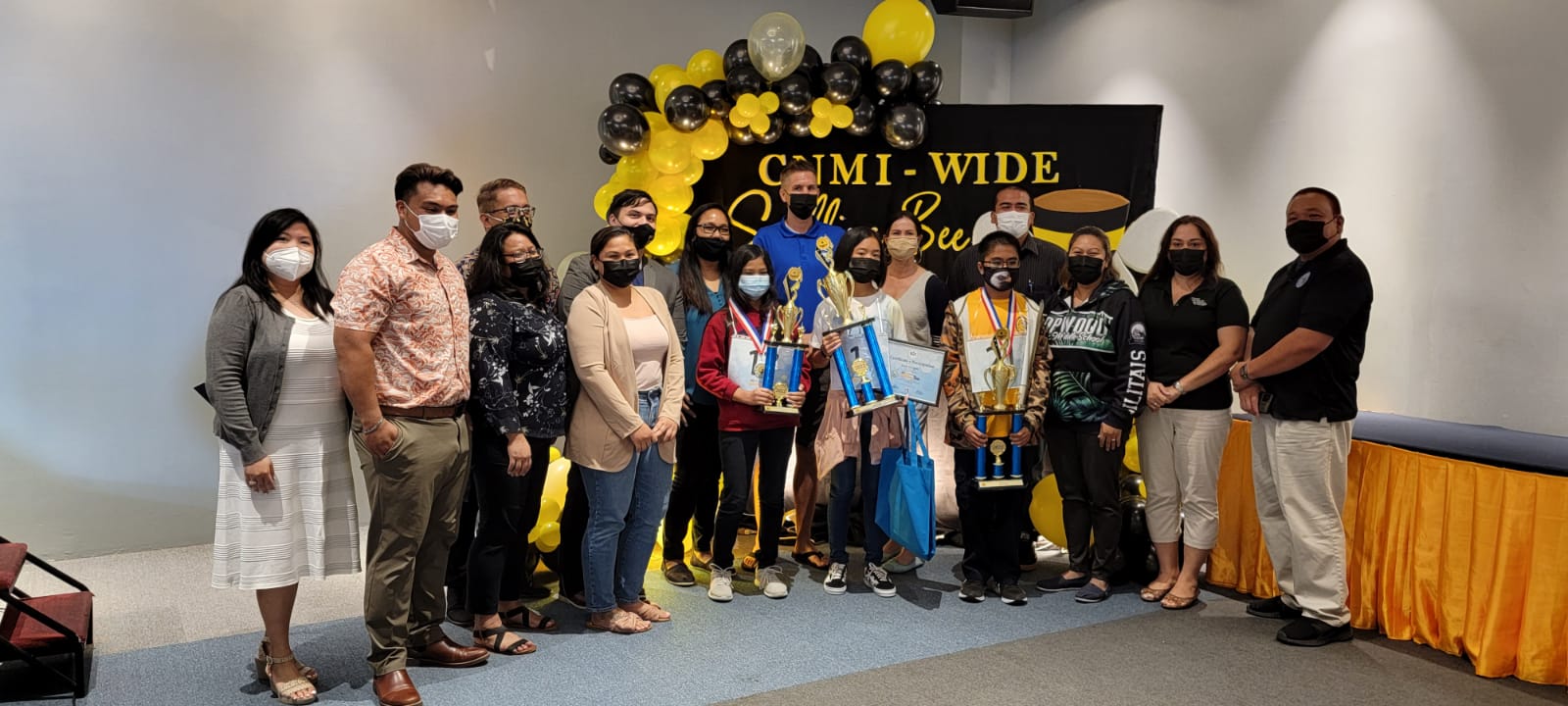 The 2022 Public School System State-Level Spelling Bee winners from left: Giselle A. Butalid, coordinator; Bobby Cruz, instructional technology and distance education director; Lorraine Catienza, competition judge; Loremel Hocog, competition judge; Jaclyn Rose Quitugua, lead judge and facilitator; Vinni Orsini, pronouncer; Dorina Salavaria, teacher; Dandan Middle School’s Mary Joy Viloria, 3rd placer; Peter Loken, Garapan Elementary School coach; Garapan Elementary School’s Maria Enriquez, champion; Megan Nevitt-Loken, Hopwood Middle School coach; Karen Manuel, Hopwood Middle School vice principal; Donna Flores, special education program director; and Associate Commissioner for Instructional Services Eric Magofna.