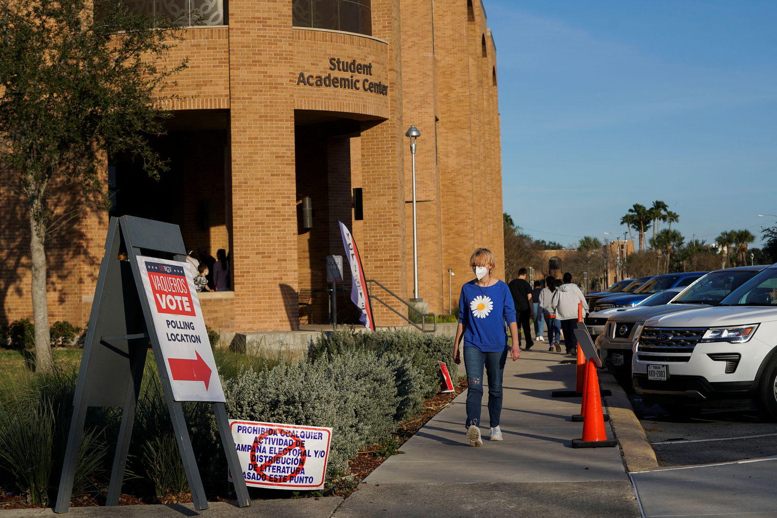 People walk towards a line to vote in the primary election in Edinburg, Texas, March 1, 2022.