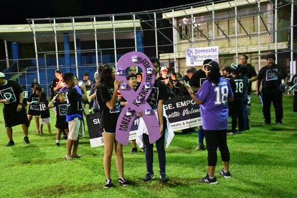 Community members in Tinian prepare lights and candles before the Walk Against Domestic Violence at the Tinian Baseball Field in 2018. 