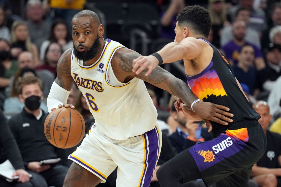 Los Angeles Lakers forward LeBron James (6) dribbles against Phoenix Suns guard Devin Booker (1) during the second half at Footprint Center in Phoenix, Arizona on March 13, 2022.