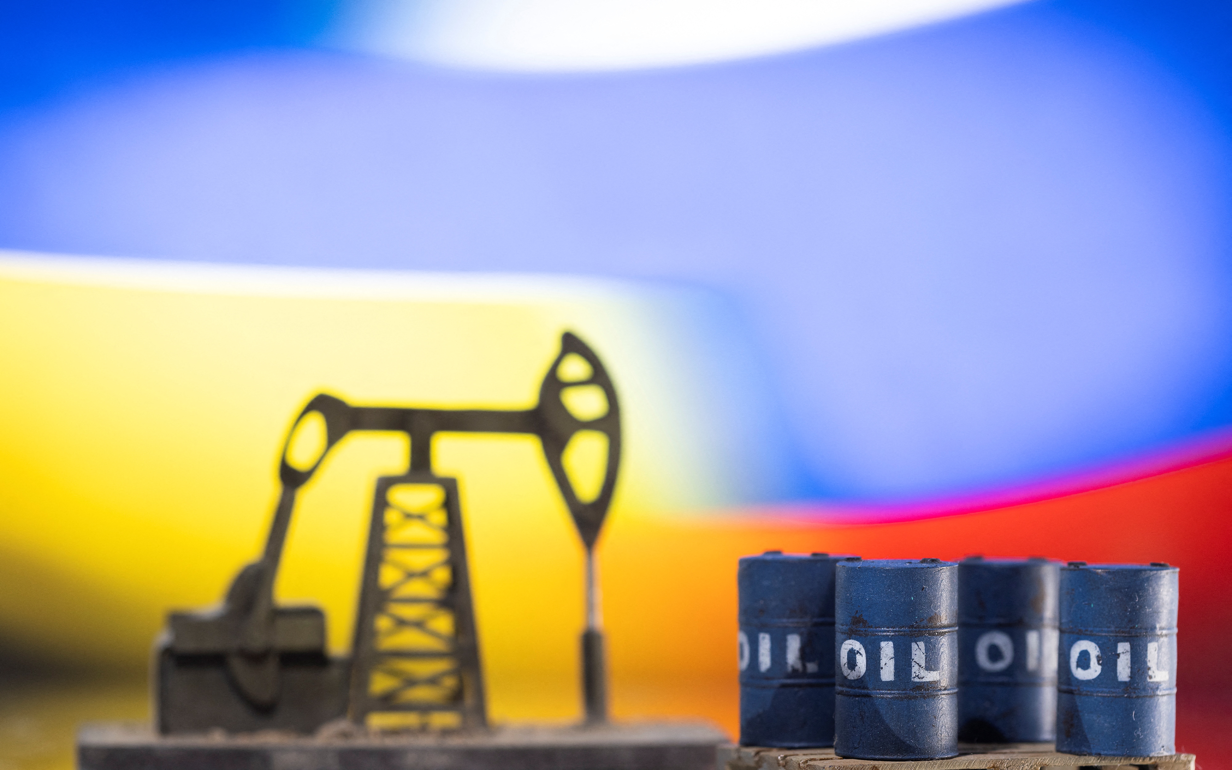 Models of oil barrels and a pump jack are displayed in front of Ukrainian and Russian flag colors in this illustration taken on Feb. 24, 2022.