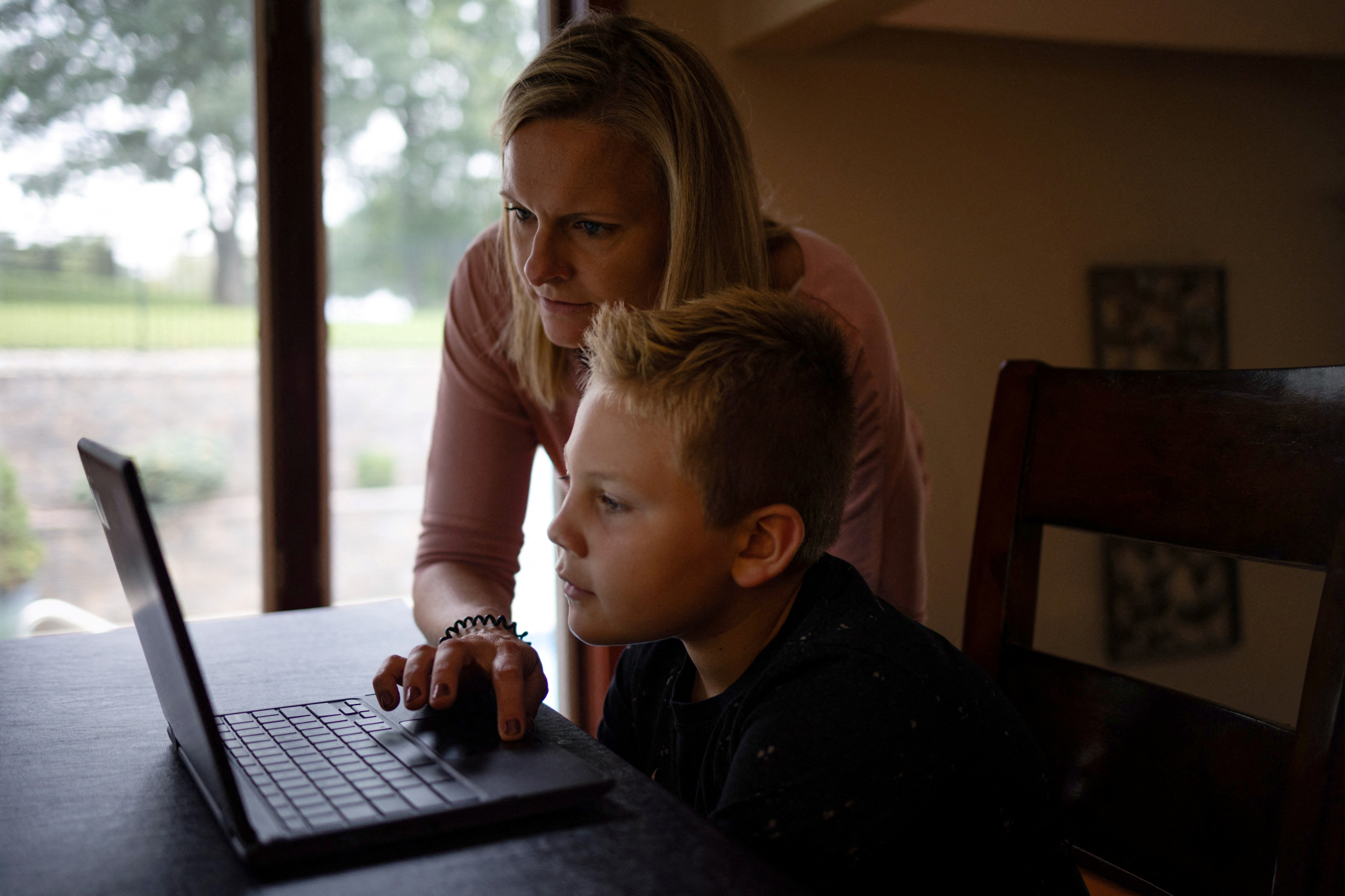 A mother helps her son with his homework at their home in Pennsylvania on Sept. 22, 2021.
