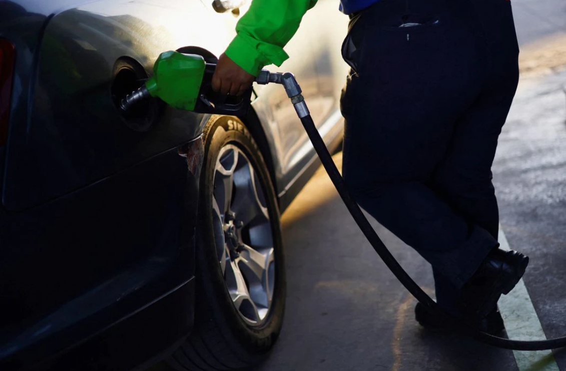 A worker fills a car belonging to a Texas resident, with gasoline at a gas station following increased fuel prices in U.S., in Ciudad Juarez, Mexico on March 14, 2022.