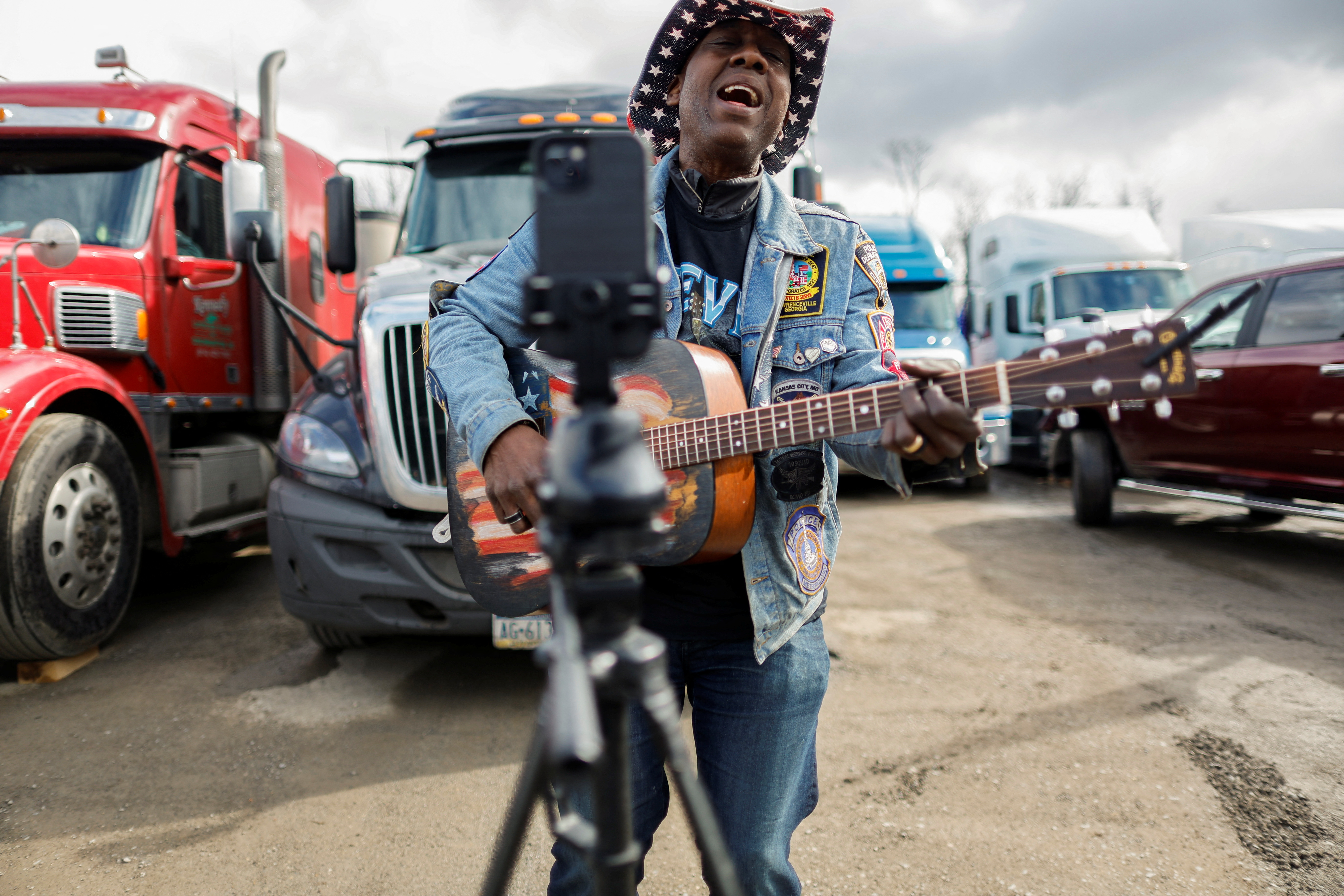 A singer livestreams a song as participants gather at a rally at Hagerstown Speedway held by activists from a convoy that traveled across the country headed to Washington, D.C. to protest coronavirus disease related mandates and other issues in Hagerstown, Maryland, March 26, 2022.