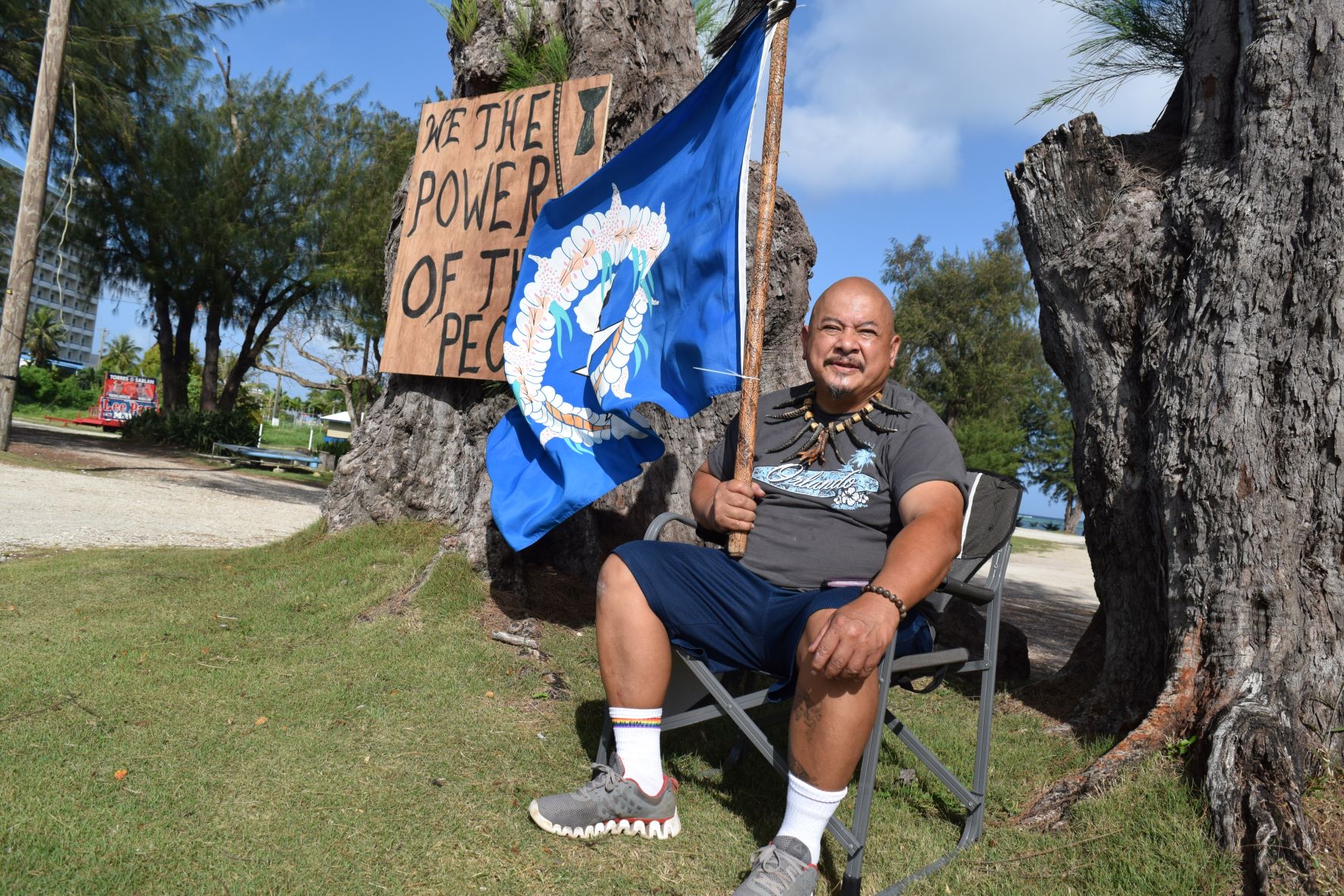 Raymond Borja Quitugua holds a CNMI flag while staging a protest  across from the Commonwealth Election Commission office in Susupe on Wednesday.