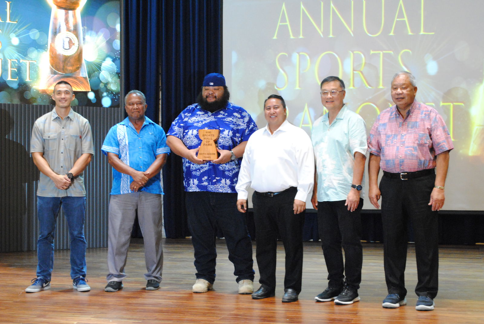Keith Nabors, third left, poses for a photo with NMI Sports Hall of Fame committee members James Lee, left, Ray Tebuteb, 2nd left, Gov. Ralph DLG Torres,  3rd right, Northern Marianas Sports Association President Jerry Tan, 2nd right, and Saipan Mayor David Apatang, right, during the NMSA Annual Sports Banquet on Tuesday at the Kensington Hotel Saipan.
