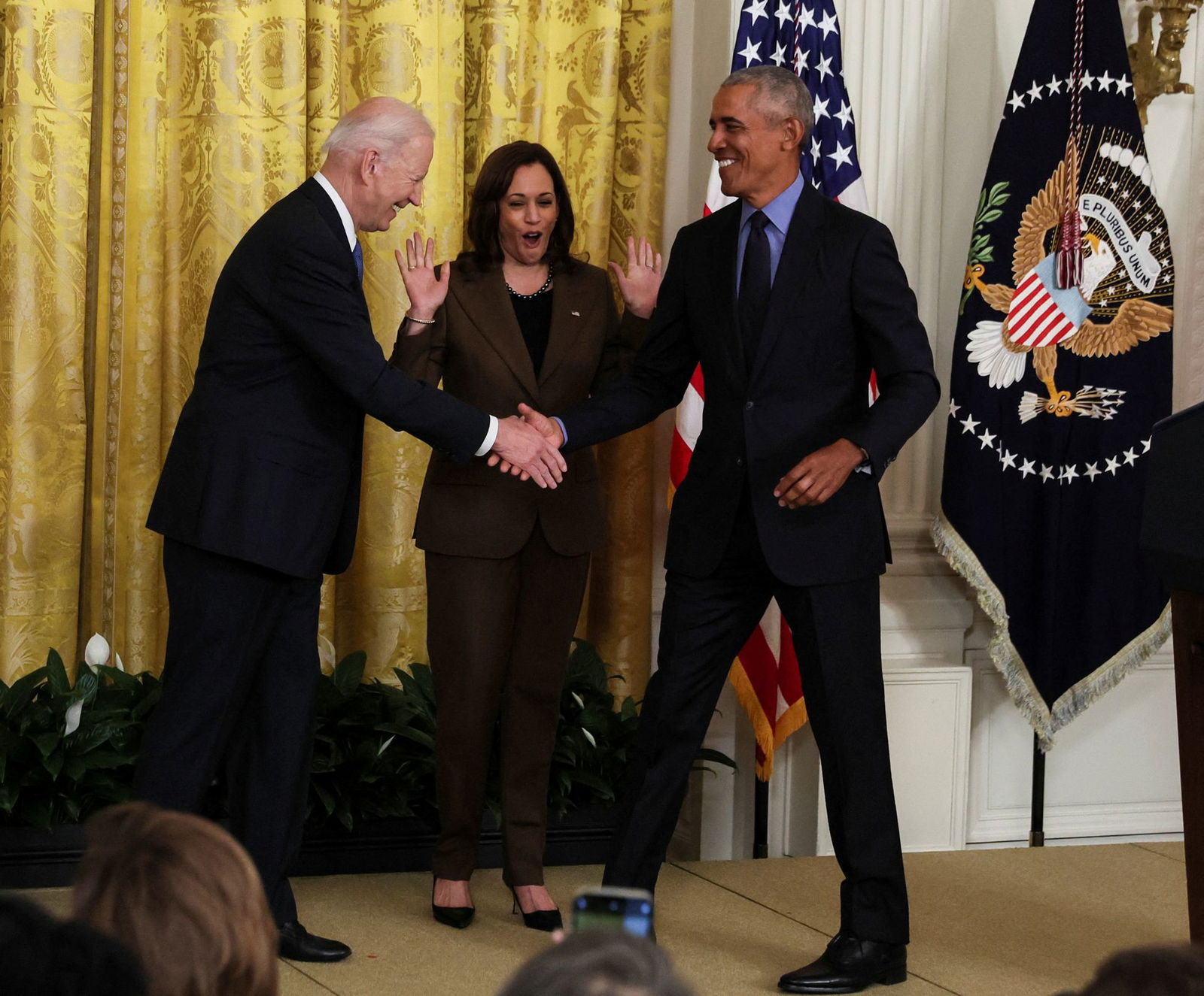President Joe Biden greets friend and former President Barack Obama during an event on the Affordable Care Act, the former president's top legislative accomplishment, as Vice President Kamala Harris reacts in the East Room at the White House in Washington, D.C., April 5, 2022.