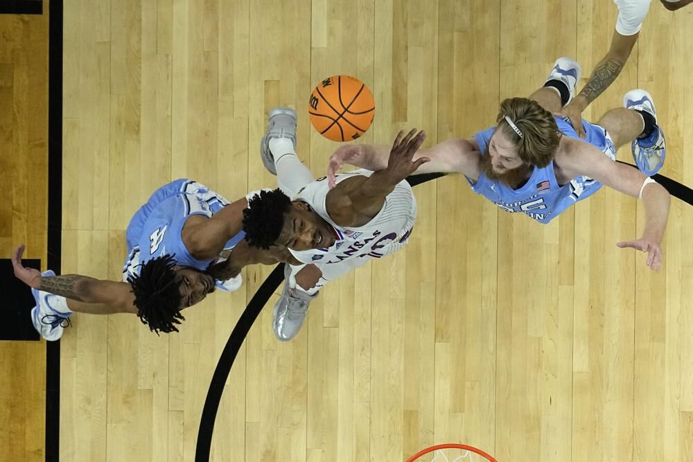 Kansas forward Jalen Wilson vies for the ball between North Carolina guard R.J. Davis, left, and forward Brady Manek during the first half of a college basketball game in the finals of the Men's Final Four NCAA tournament, Monday, in New Orleans.