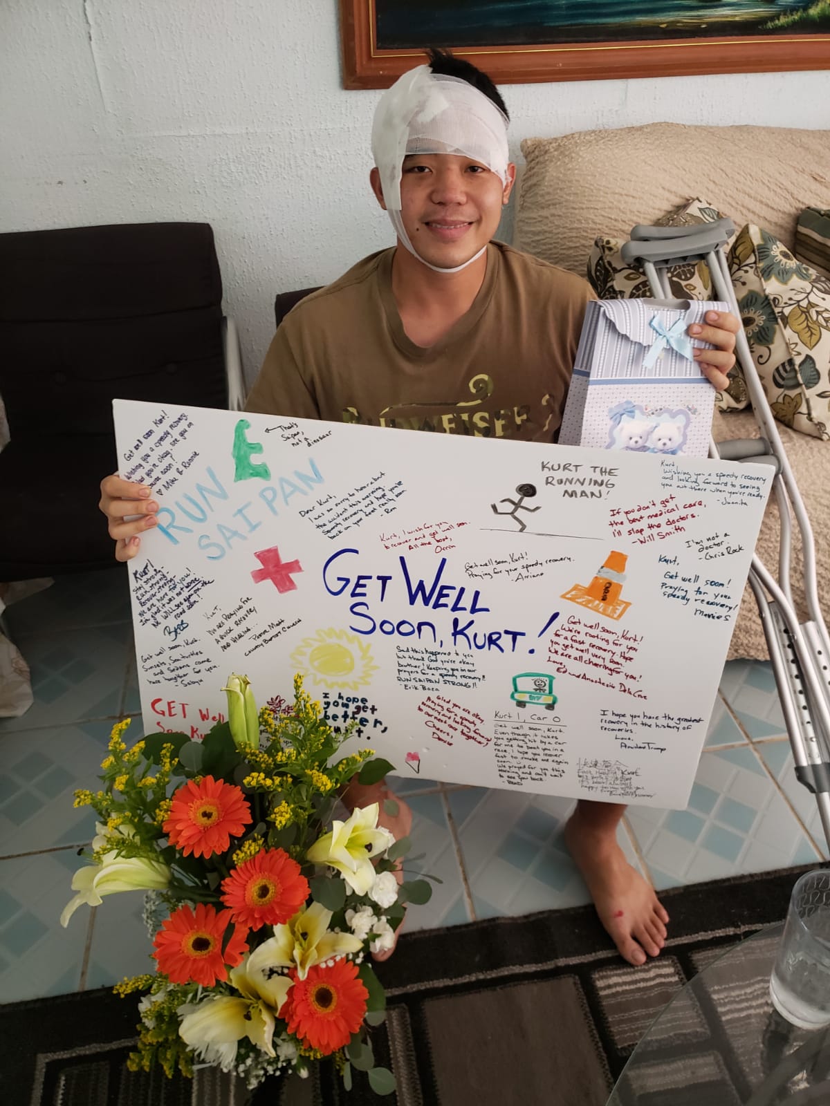 Kurt Songsong, who was struck by a car on Saturday morning, shows a large get-well-soon card he received from friends.