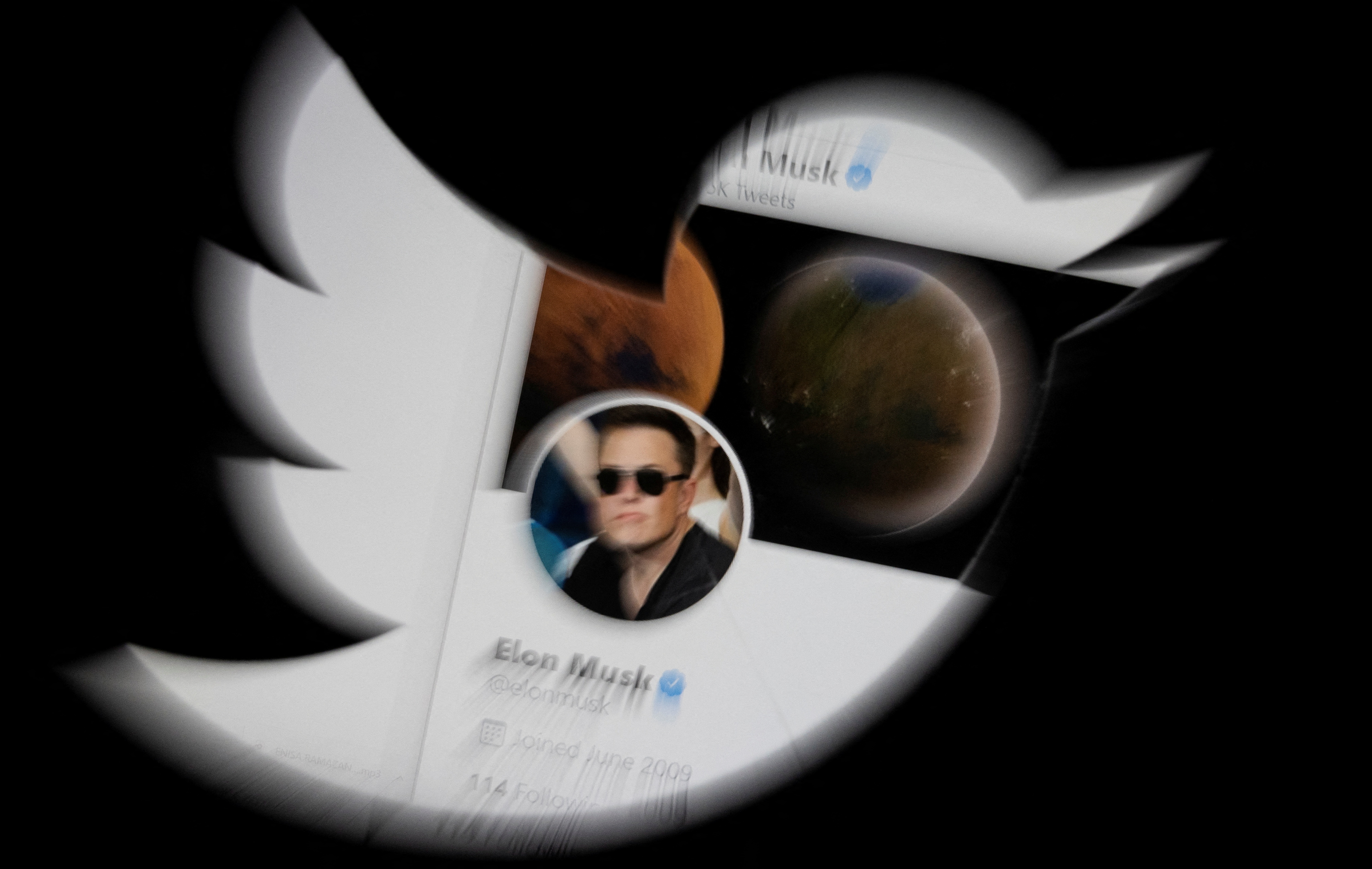 Elon Musk's twitter account is seen through the Twitter logo in this illustration taken, April 25, 2022.