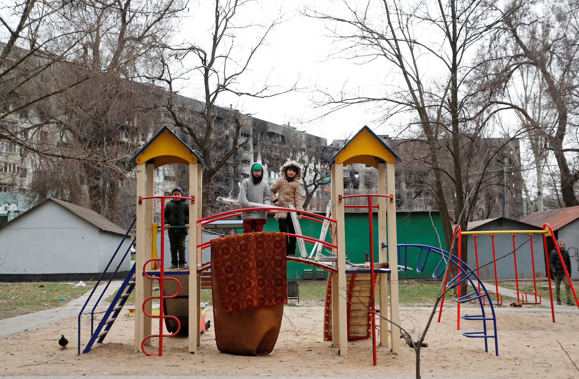 In the southern port city of Mariupol, Ukraine, children play at the playground near an apartment building damaged during the Russian invasion of Ukraine on April 4, 2022.