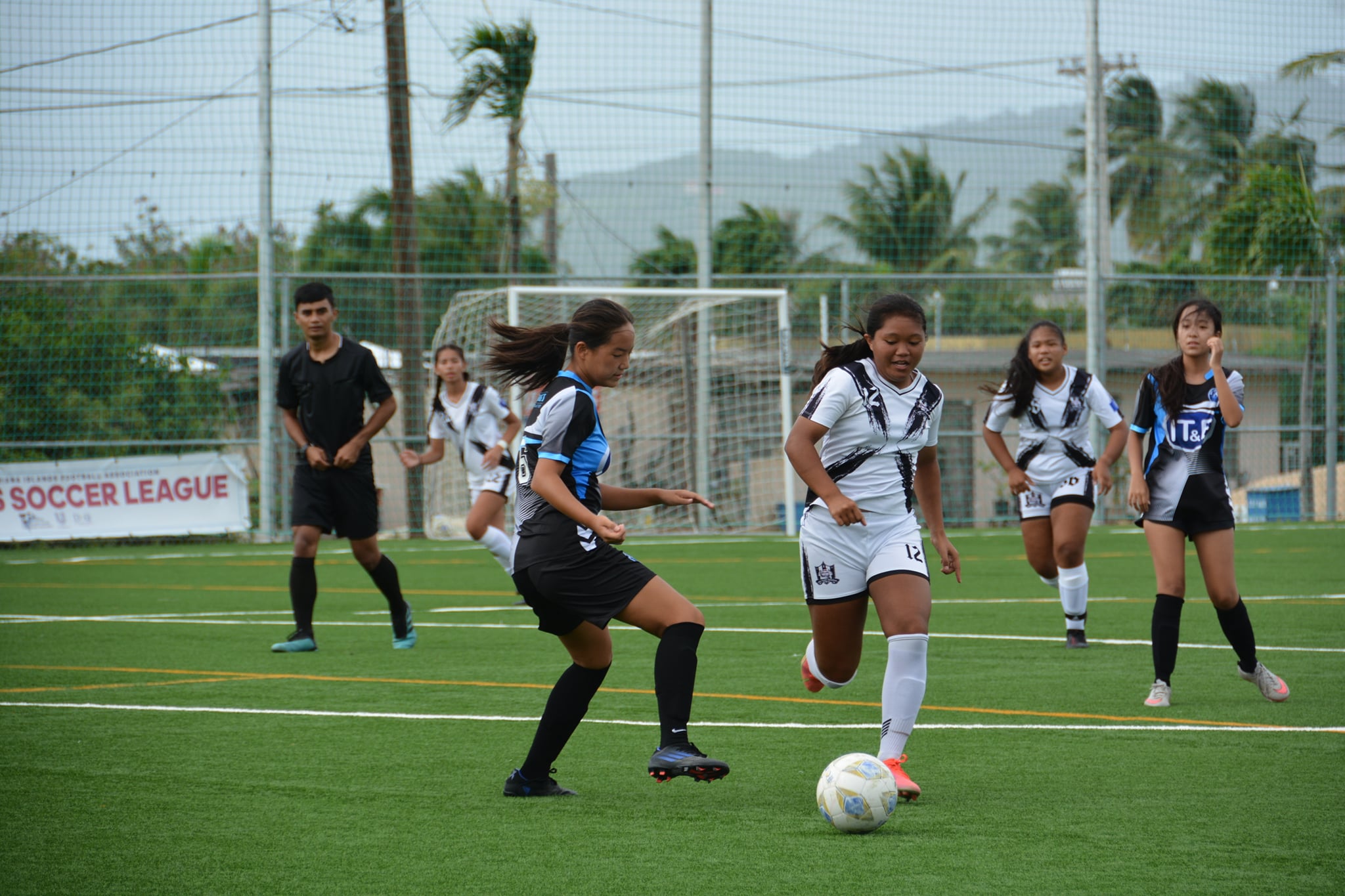 Saipan United’s Briannie Elchalico dribbles past a defender during a U13 girls division game of the TakeCare Youth Soccer League Saturday at the NMI Soccer Training Center.