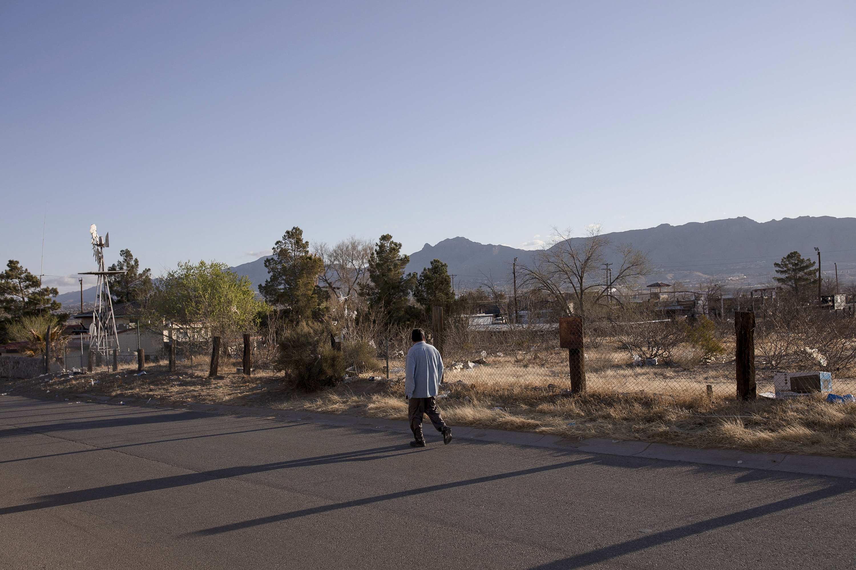 A man walks on a road through a neighborhood near the U.S.-Mexico border in Sunland Park, New Mexico, March 23, 2022.