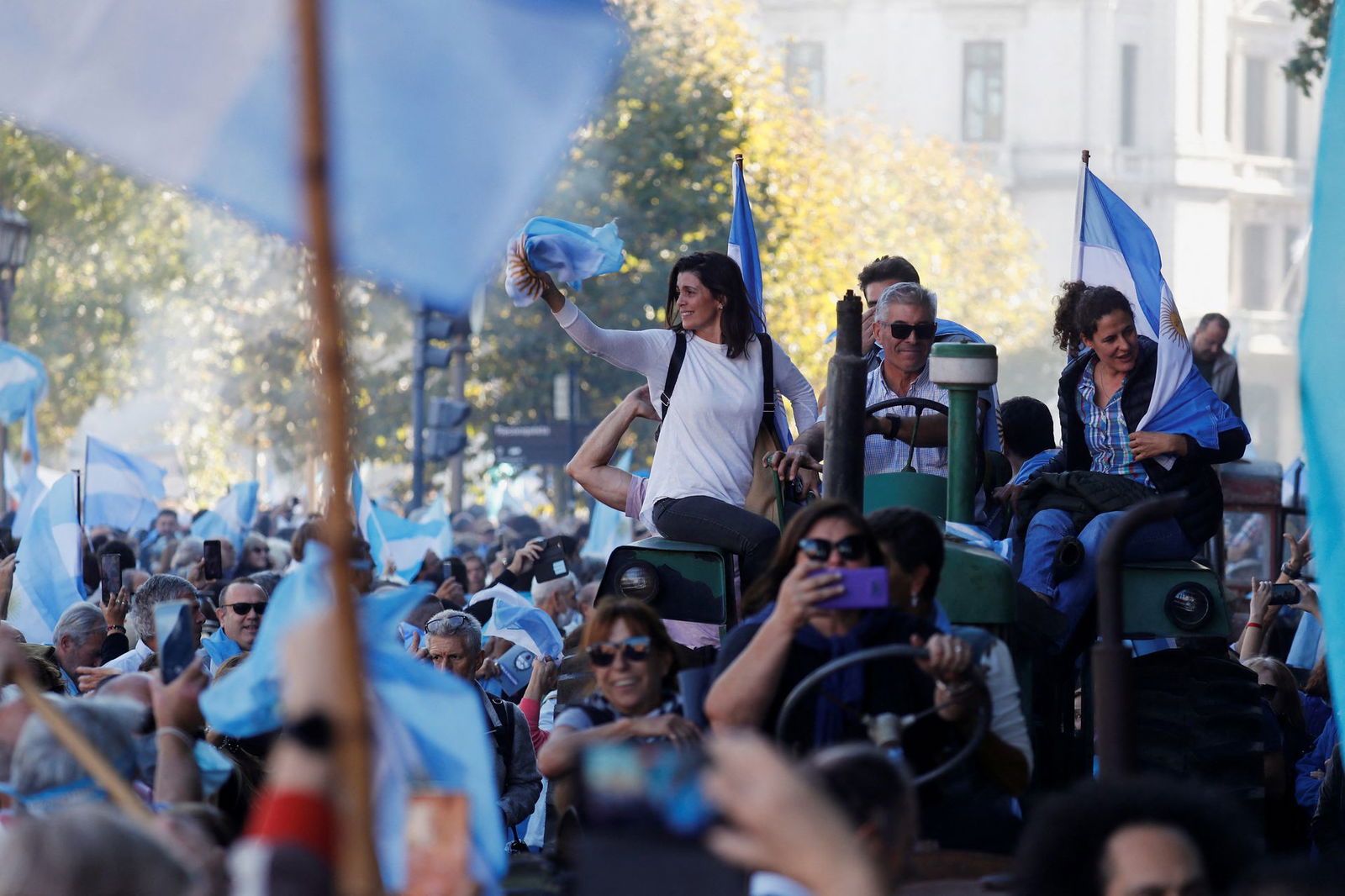 People hold Argentine flags as farmers ride tractors at Plaza de Mayo to protest new export taxes on farm goods applied by President Alberto Fernandez's administration, in Buenos Aires, Argentina, April 23, 2022.