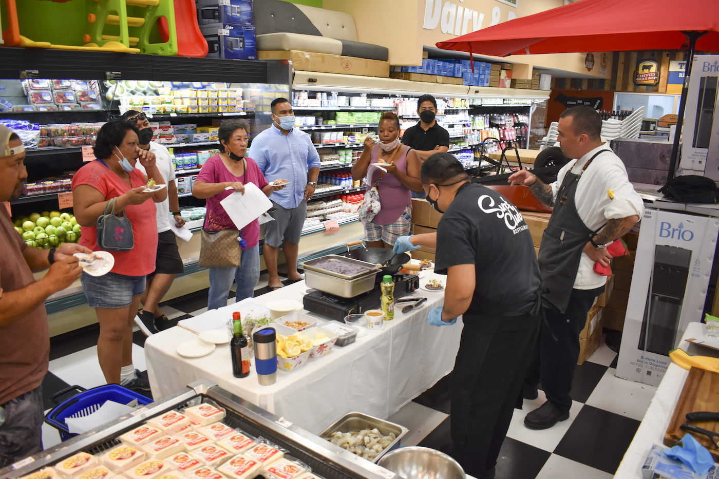 Customers listen while sampling a dish prepared by Executive Chef Richard “Conno” Pierce during a cooking demonstration at Payless SuperFresh.
