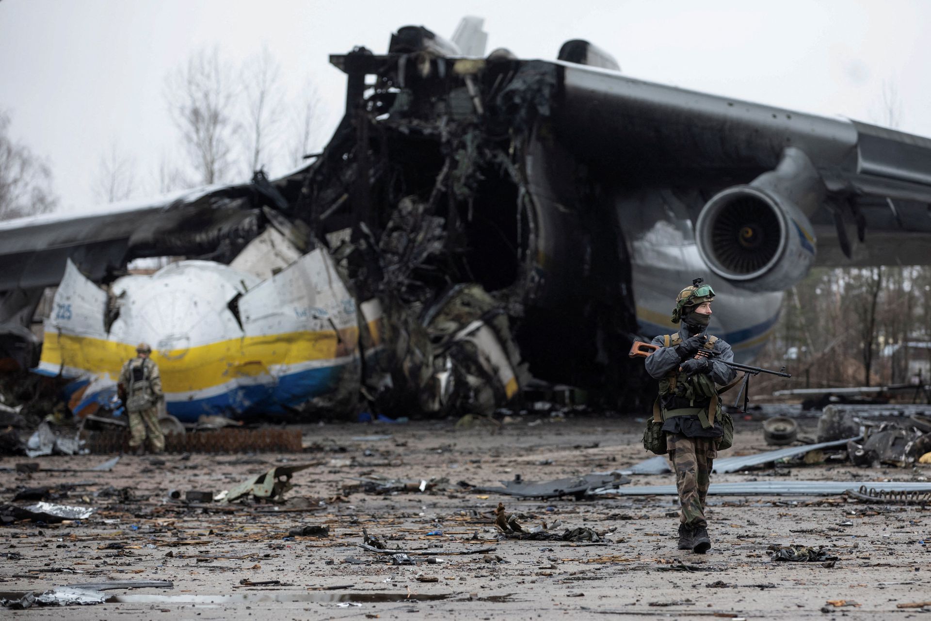 Ukrainian service members walk near a Ukrainian flag, amid Russia's invasion of Ukraine, in the village of Kozarovychi, in Kyiv region, Ukraine on April 2, 2022.
