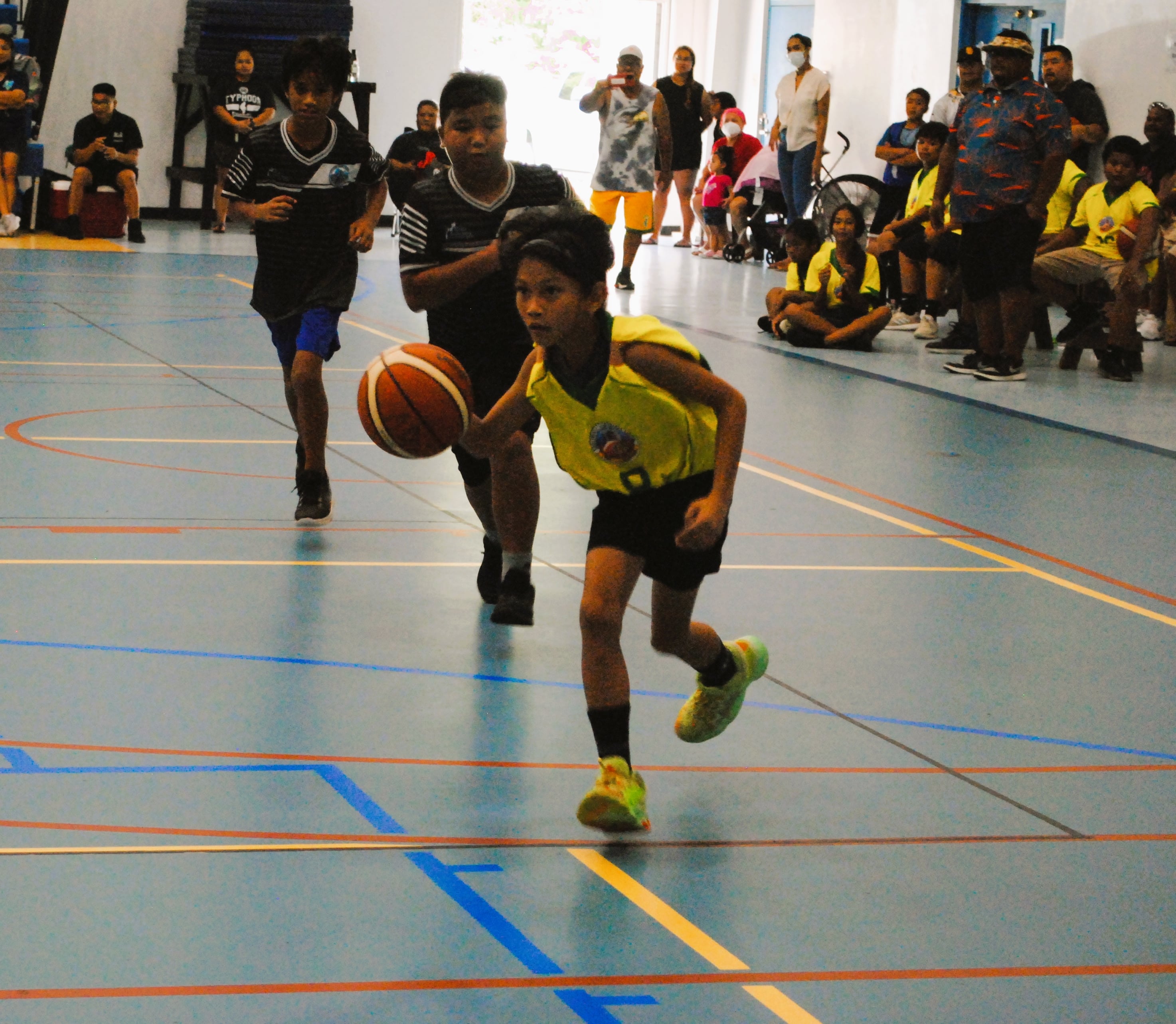 KoES 1's Andrei Tenorio dribbles past defenders for the open layup during a playoff game of the IT&E Interscholastic Co-ed Elementary School Basketball League Saturday at the MHS gym.