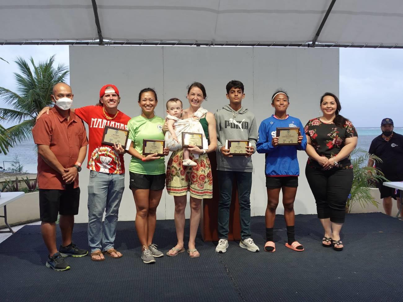 Top 10K finishers in Saipan Marathon 2022, Keith Longuski, second, left, and Kaithlyn Chavez, second right, receive their awards with other top finishers on April 9, 2022, at the event awards ceremony at Aqua Resort Saipan.  Also pictured are Northern  Marianas Athletics  General  Secretary  Robin  Sapong-Eugenio,  left,  and Marianas Visitors Authority Managing Director Priscilla M. lakopo, right.