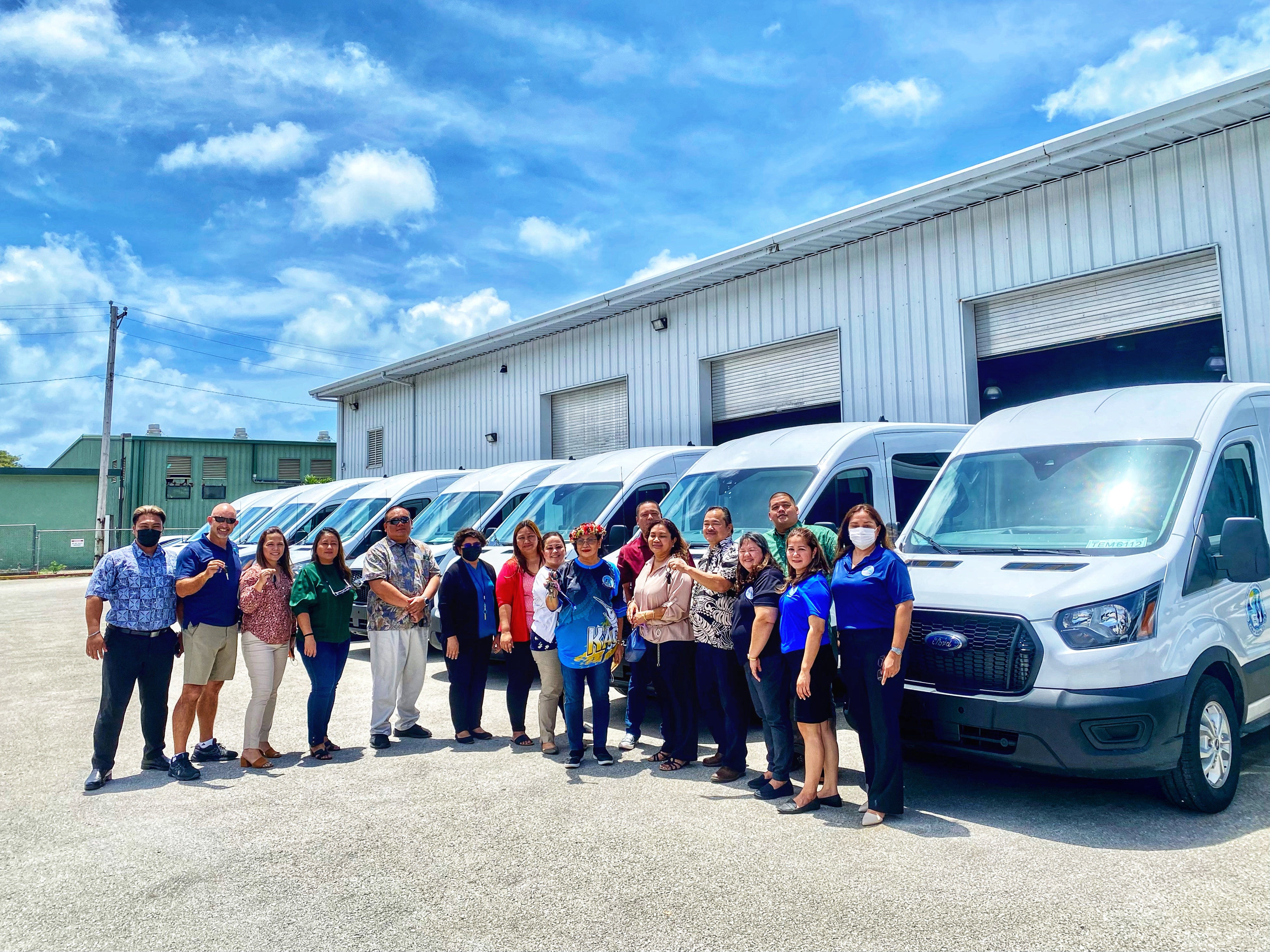 Commissioner of Education Dr. Alfred B. Ada, 5th right, and  the other members of the Public School System management teams pose for a photo with the 16 new vans Tuesday at the PSS Office of Pupil Transportation in Lower Base. 
