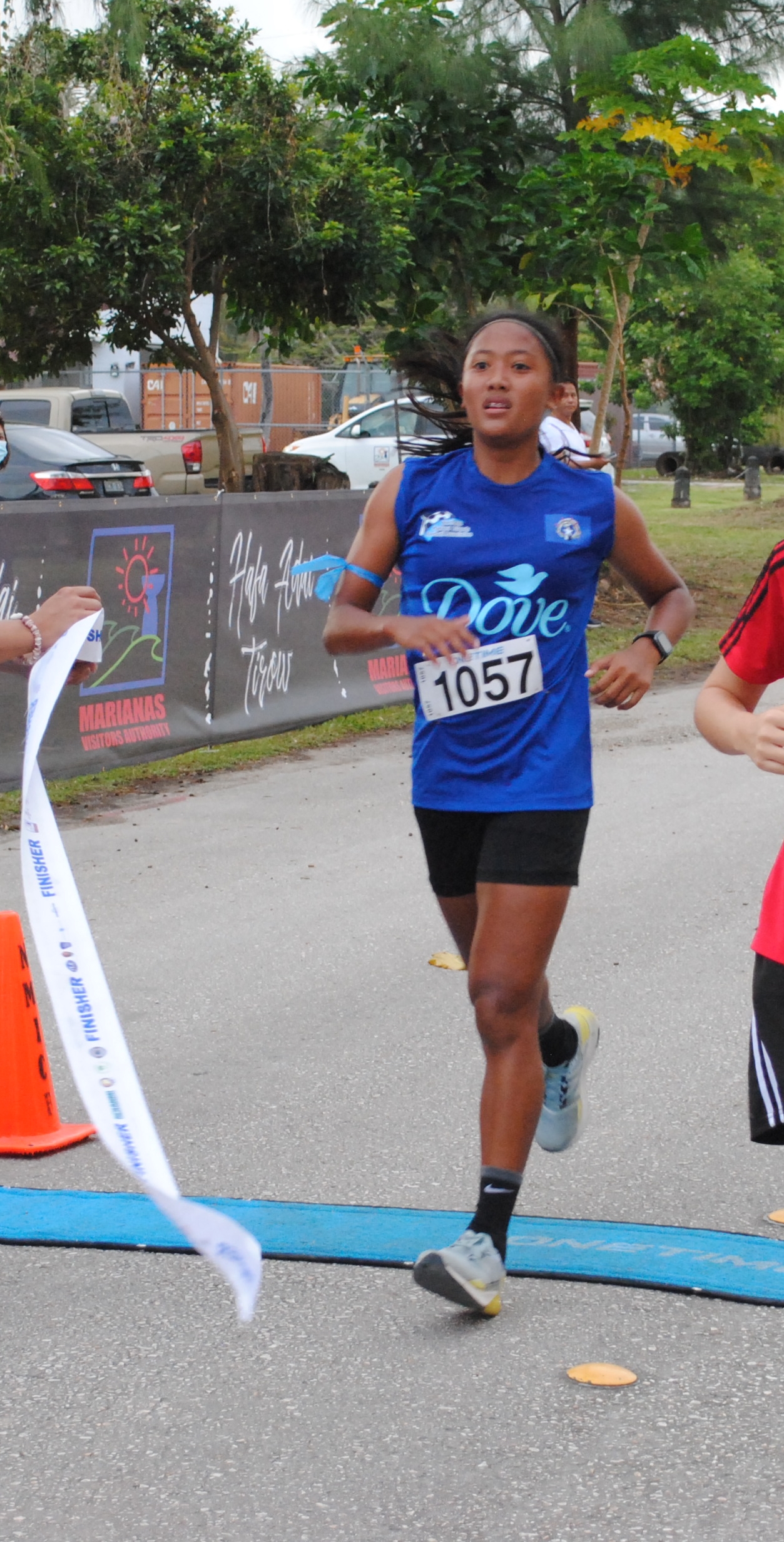 Kaithlyn Chavez takes a breather as she crosses the finish line of the Saipan Half Marathon/10K category on Saturday at American Memorial Park.