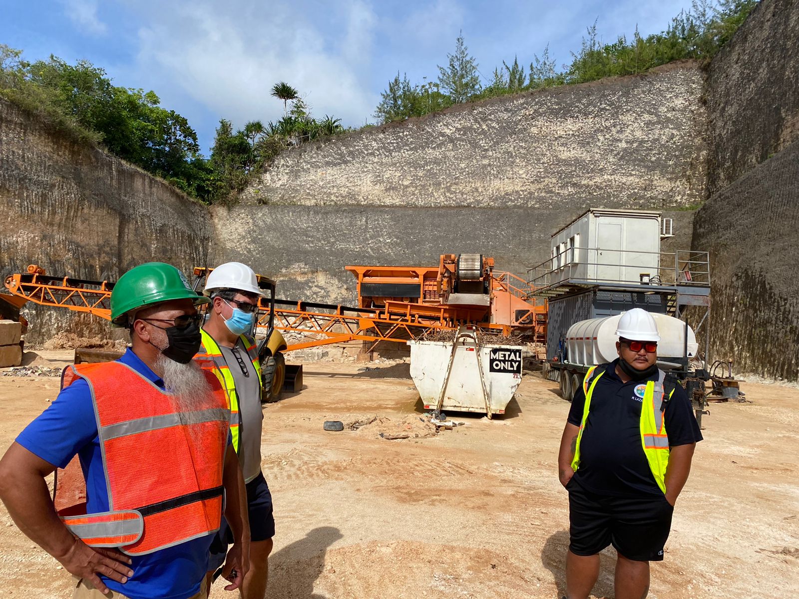 From left: Guam Environmental Protection Agency Solid Waste Program Manager Glenn San Nicolas, Department of Public Works  Tinian Resident Department Head Joal Untalan, and DPW Tinian Branch Manager of the Solid Waste Division Ray Lazaro speak among themselves during a site visit to the JMC Repurposing Facility in Guam.