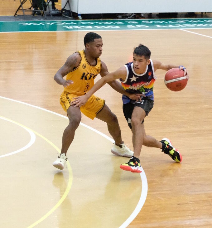 The NMI’s Leo Naraja, right, dribbles and keeps the ball away from a KFC Bombers defender during their friendly game Friday in the NMI Friendship Classic at the University of Guam Calvo Field House.
