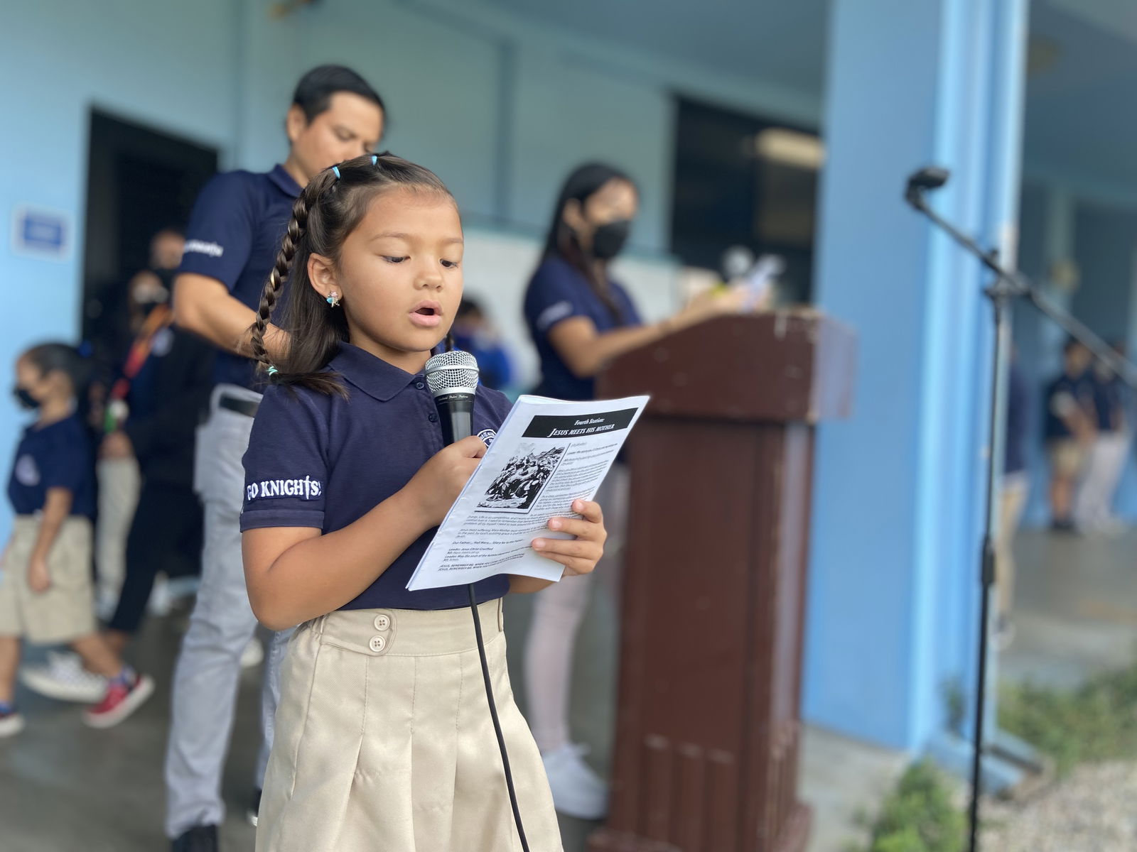 As part of the school’s  of Holy Week, Mount Carmel School’s first grade student Mika Kate Backe reads “The Third Station — Jesus Falls for the First Time” during the Stations of the Cross.