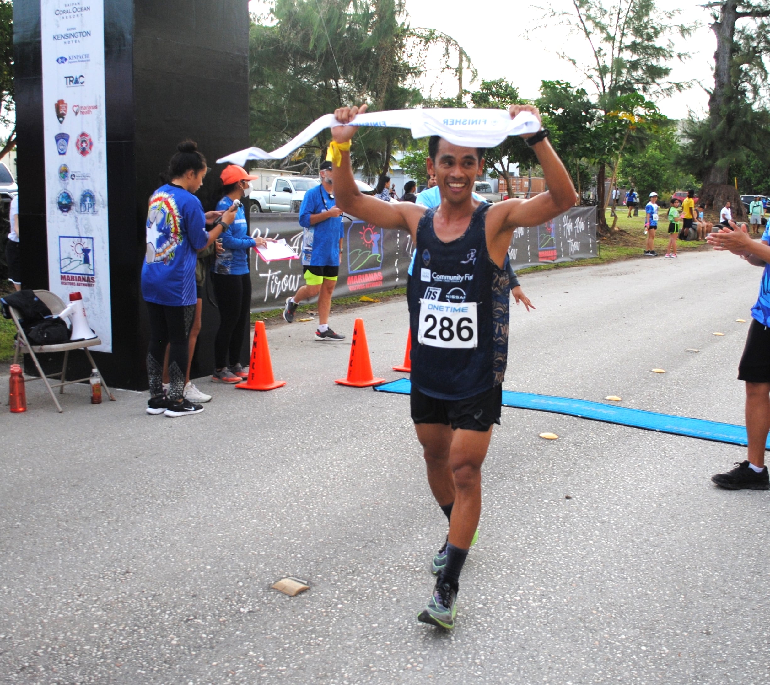 Ryan Matienzo celebrates after finishing first overall in the Saipan Half Marathon at American Memorial Park on Saturday.