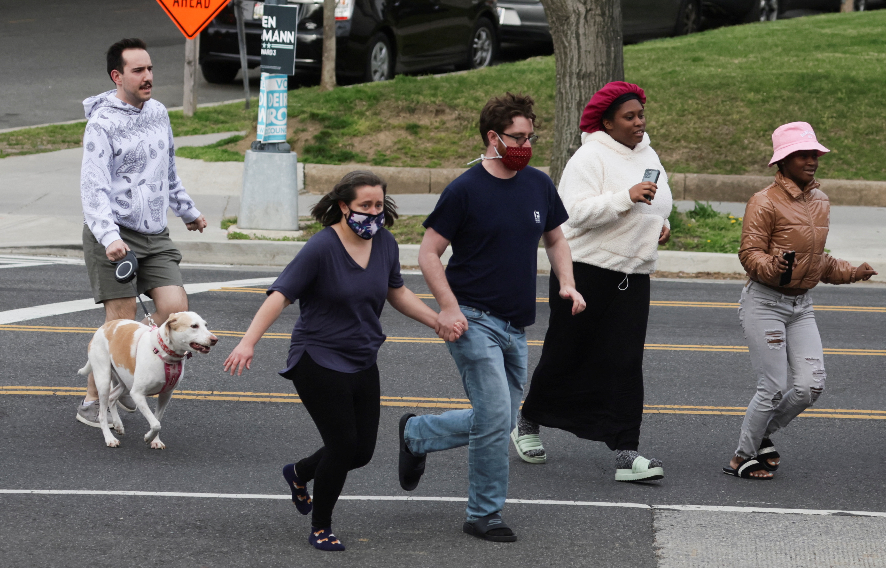 Local residents run to safety as police evacuate people from the area of the scene of a reported shooting and active shooter near Edmund Burke Middle School in the Cleveland Park neighborhood of Northwest Washington, D.C., April 22, 2022.