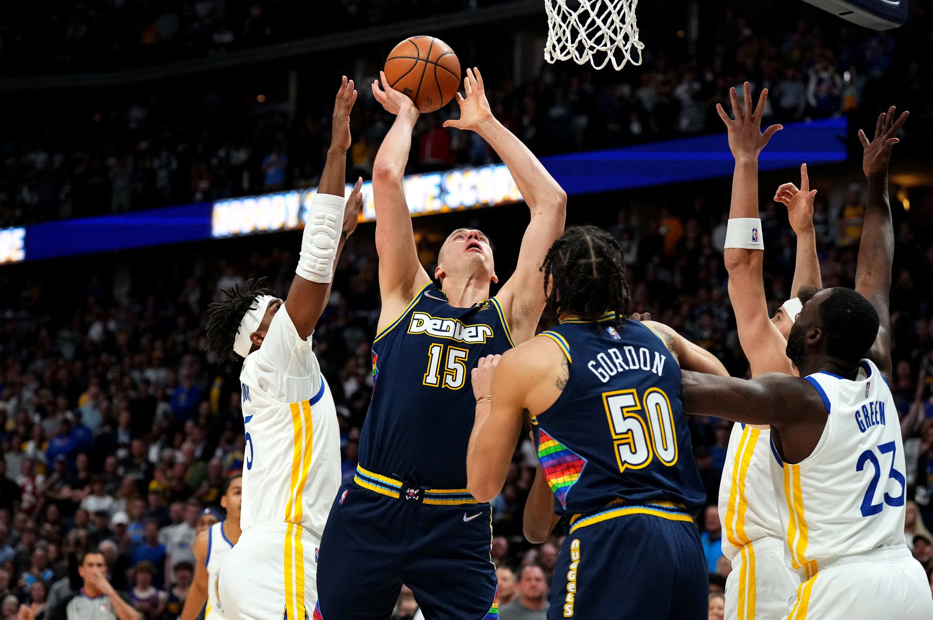 Denver Nuggets center Nikola Jokic (15) shoots past Golden State Warriors center Kevon Looney (5) in the first quarter of the NBA playoffs’ first round at Ball Arena in Denver, Colorado on April 24, 2022.