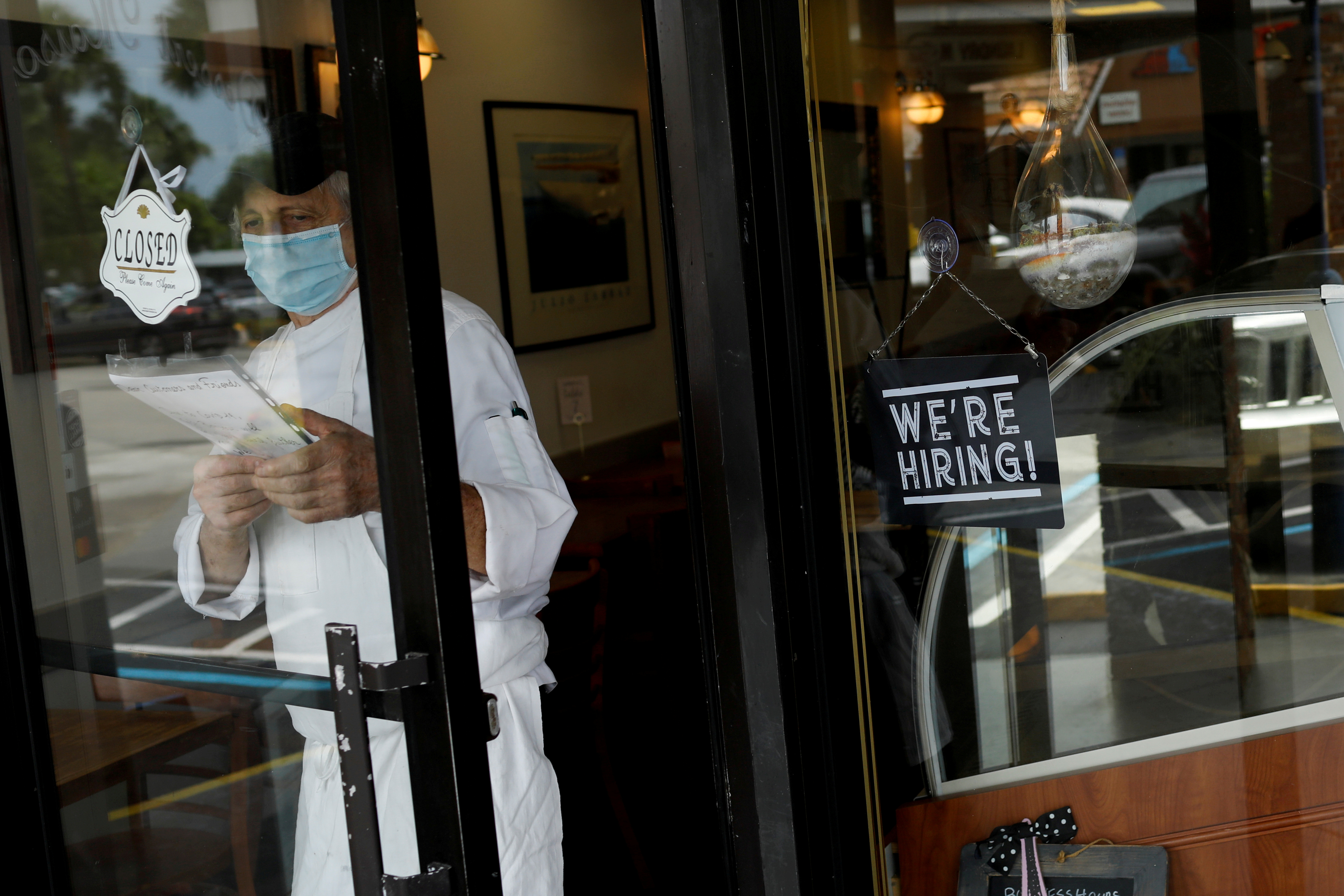 A "We're Hiring" sign advertising jobs is seen at the entrance of a restaurant in Miami, Florida, May 18, 2020.