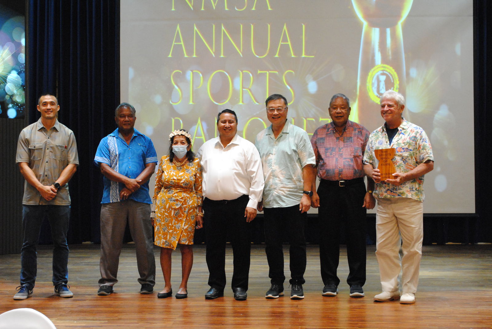Bob Coldeen, right, holds the NMI Sports Hall of Fame trophy as he poses for a photo with his wife Martha, third left,  NMI Sports Hall of Fame committee members James Lee, left, Ray Tebuteb, 2nd left, Gov. Ralph DLG Torres, center, Northern Marianas Sports Association President Jerry Tan, 3rd right, and Saipan Mayor David Apatang, 2nd left, during the NMSA Annual Sports Banquet on Tuesday at the Kensington Hotel Saipan.