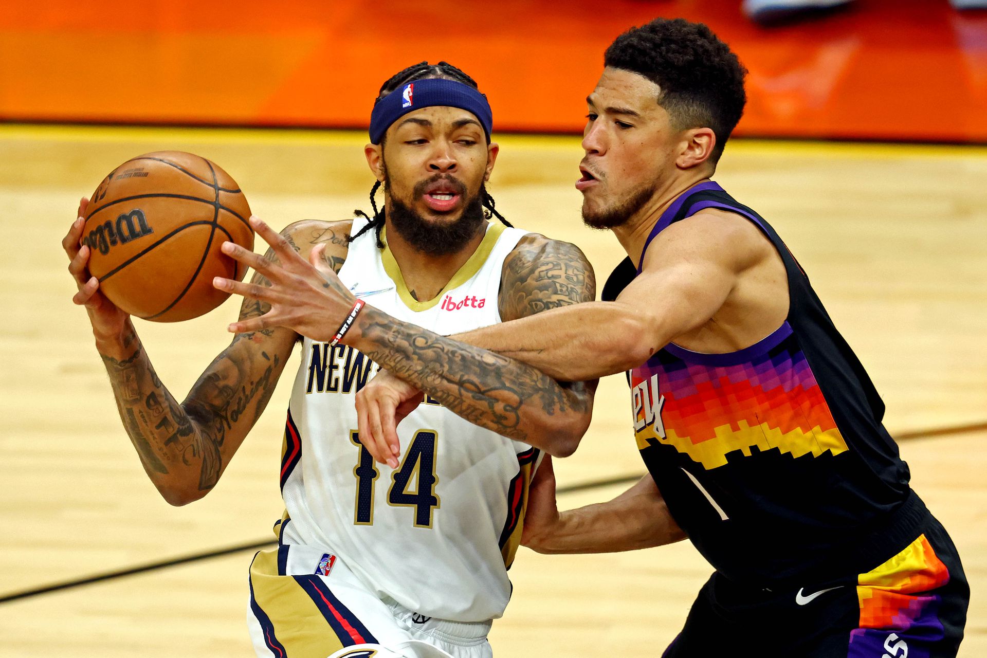 New Orleans Pelicans forward Brandon Ingram (14) drives to the basket against Phoenix Suns guard Devin Booker (1) during the first quarter of game one in the first round of the 2022 NBA playoffs at Footprint Center in Phoenix, Arizona on April 19, 2022.