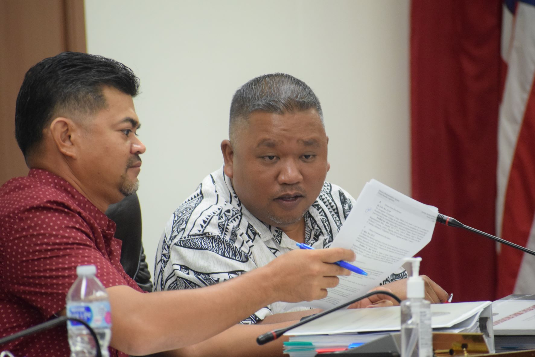 House Minority Leader Angel A. Demapan, right, looks at a document shown to him by Rep. Roy Ada during a House session early last week.