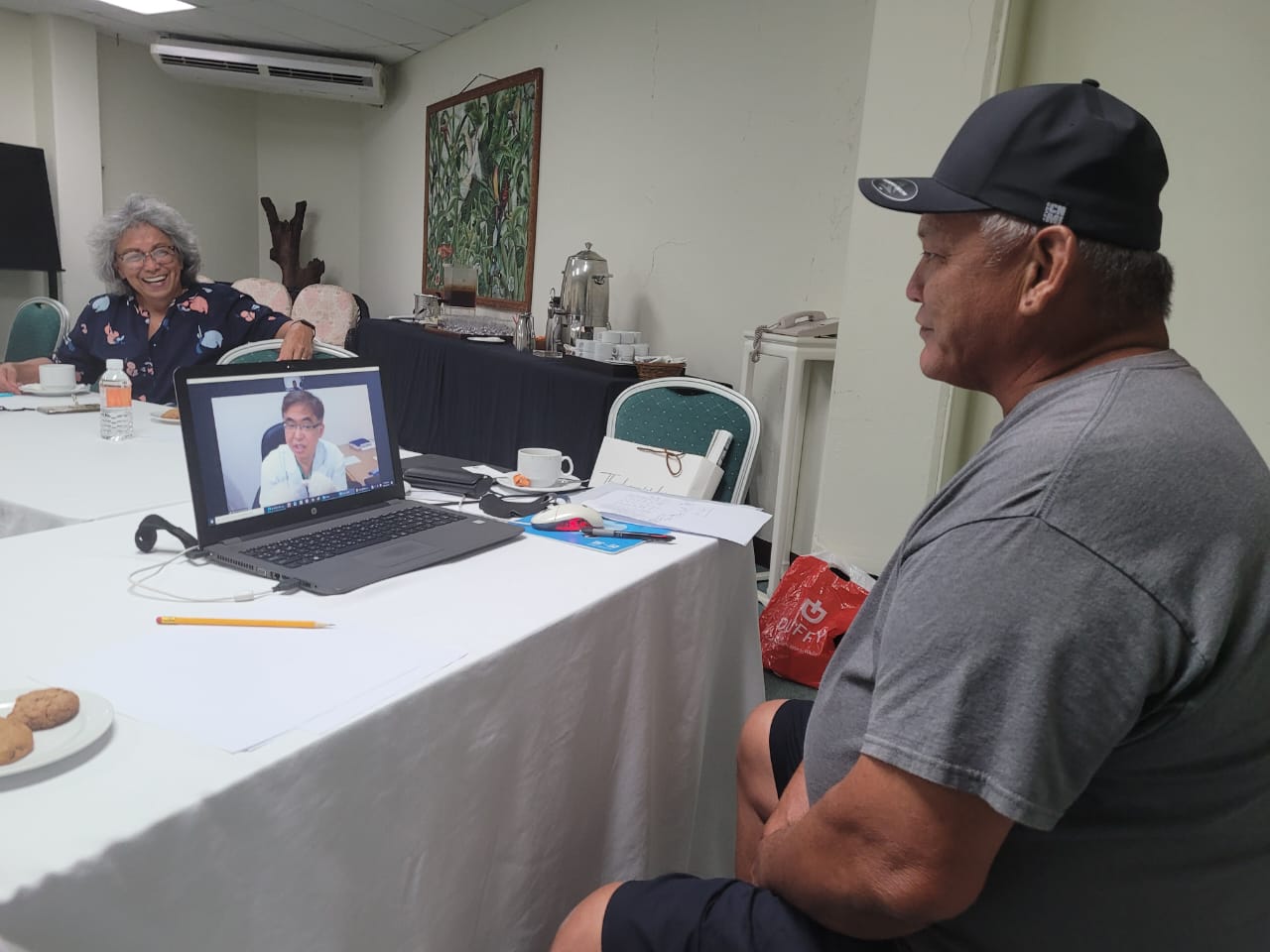 Marianas Visitors Authority board member Marian Aldan-Pierce, left, smiles as she waits for her turn to be seen by a doctor from Kang Dong Orthopedic Hospital in Busan, South Korea, via video call, in the Chamolinian Room of at Hyatt Regency Saipan on April 21, 2022.