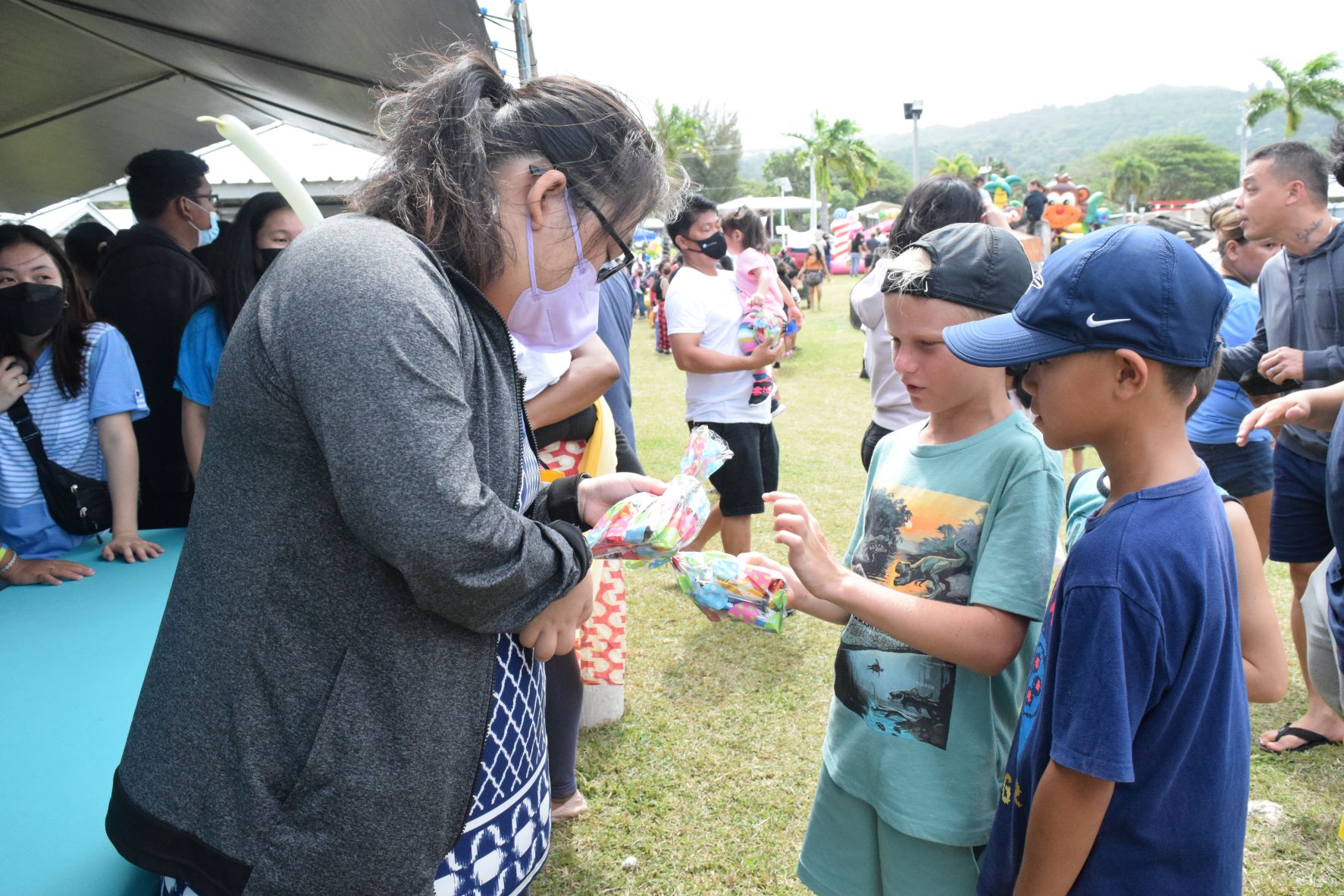 A Saipan Interact member hands candy to children.
