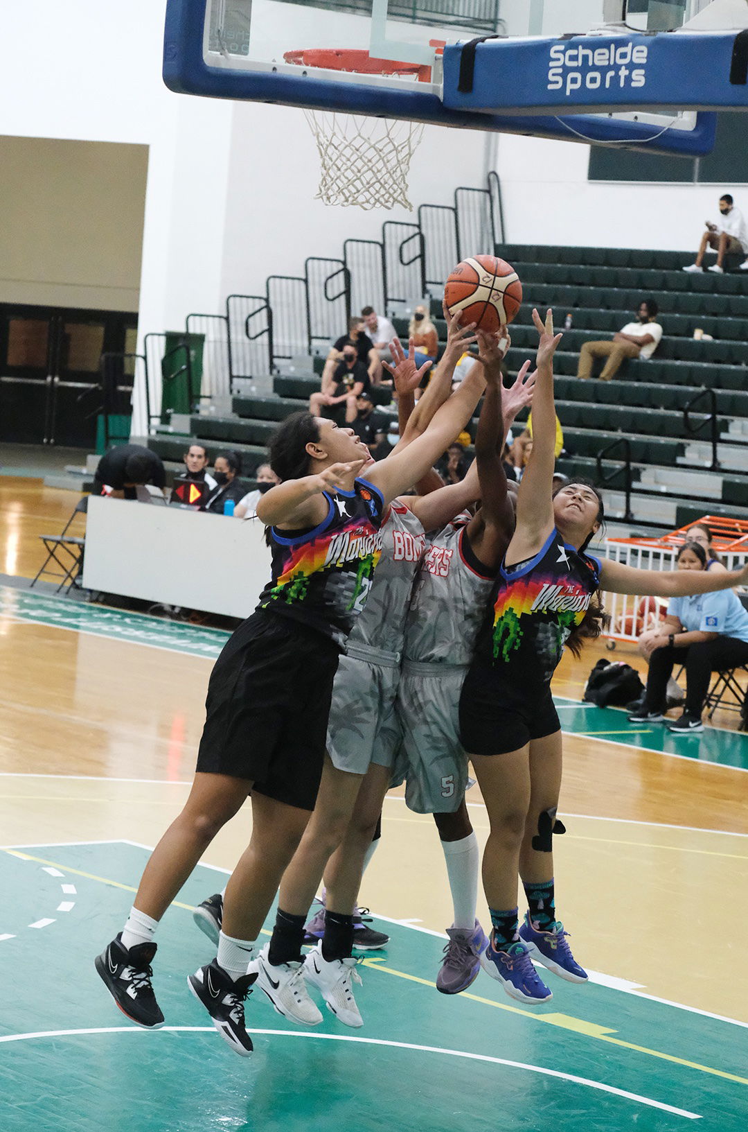 The NMI’s Azriel Fatialofa, left, and Fiona Bucalig, right, battle two Lady Bombers for the rebound during a friendly game in the NMI Friendship Classic  Friday at the UOG Calvo Field House.