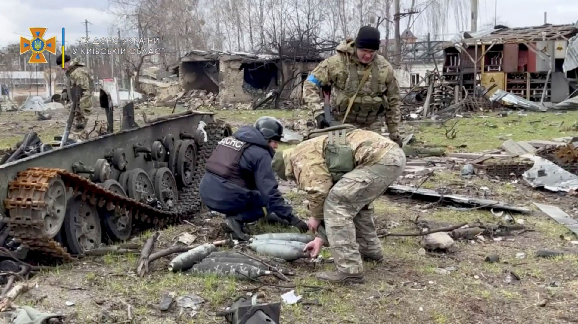 State Emergency Service members collect ordnance after Russia's withdrawal from the area, in Bucha, Ukraine, in this still image taken from video uploaded to a social media website on April 4, 2022.