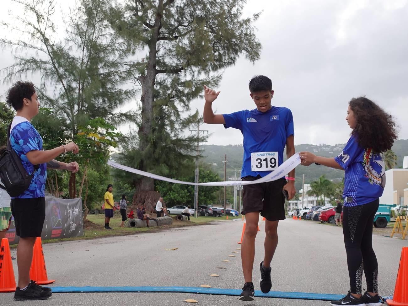 Anthony Bergancia of Northern Marianas crosses the finish line to win second place in the Men's Division of the 5K course of Saipan Marathon 2022 on April 9, 2022.