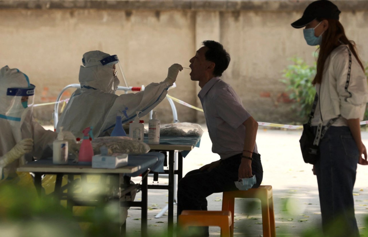 A medical worker takes a swab sample from a person for a nucleic acid test at a makeshift testing site, amid the coronavirus disease outbreak, in Beijing, China, May 23, 2022.