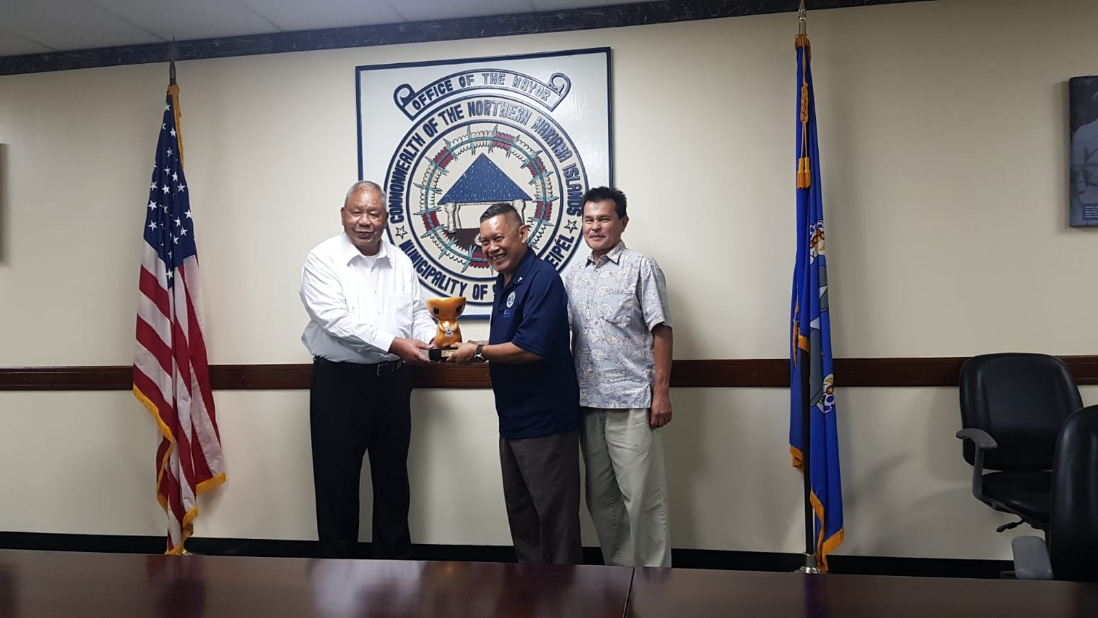 Saipan Mayor David M. Apatang hands a latte-shaped "animu" as a token of the island’s appreciation to Guam-CNMI state chairman Ret. Lt. Col. Rey Llaneta.Â