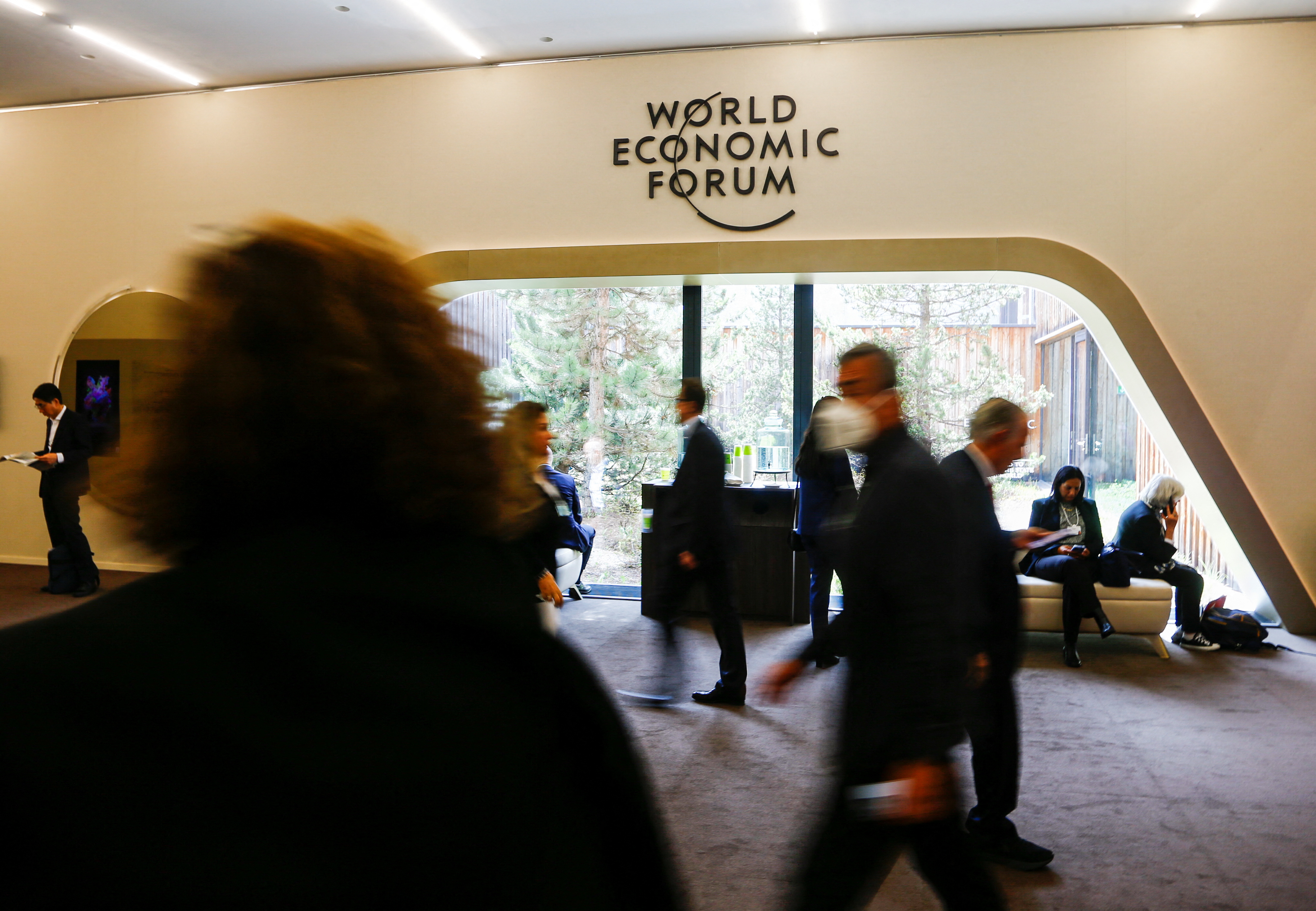 General view of people walking past the World Economic Forum logo during the forum in Davos, Switzerland, May 23, 2022.