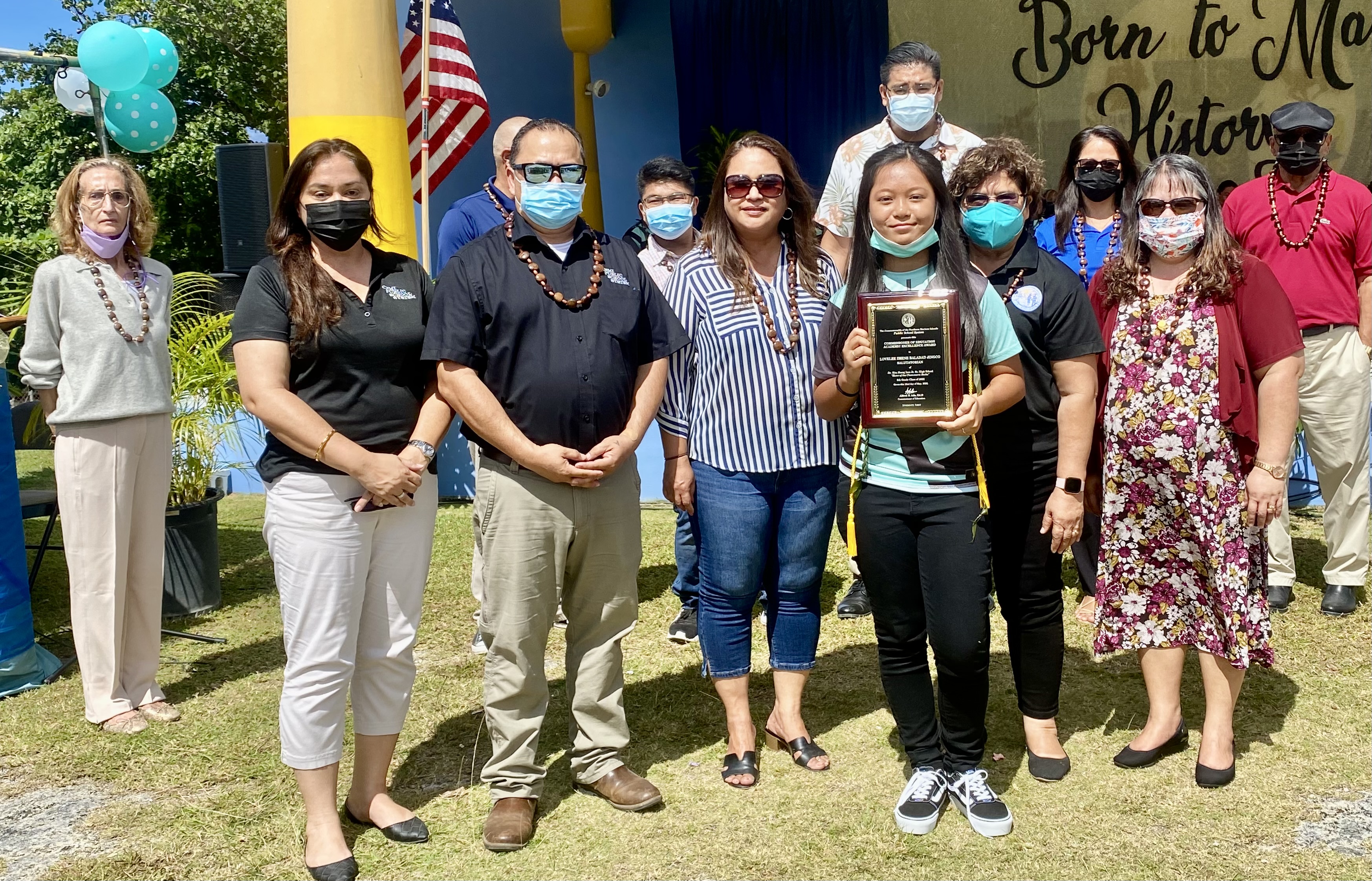 Junior high school class salutatorian and Commissioner of Education awardee Lovelee Zhene Balidad Jingco receives her plaque from Commissioner of Education Dr. Alfred B. Ada, PSS Senior Directors Jackie Quitugua, Dr. Yvonne Pangelinan, Dr. Rizalina Liwag, and Special Education Director Donna Flores.