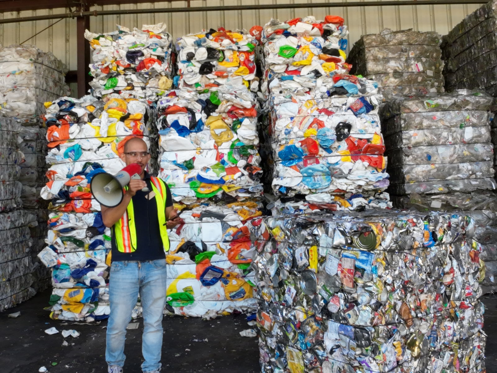 Recycling coordinator for Marin Sanitary Service Carlos Hernandez walks the CNMI delegation through how the facility processes the plastic and aluminum items it receives. Behind and beside Hernandez are bales of plastic and aluminum.