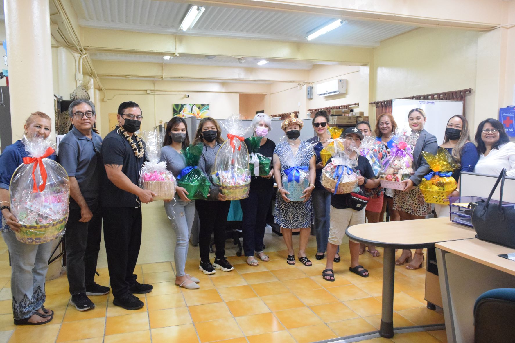 Women's Coalition for Arnold-Dave 2022 founder Wella Palacios, center, and Karidat Executive Director Lauri Ogumoro, sixth left, hold gift baskets as they pose for a photo with coalition members and Karidat staff in this file photo.