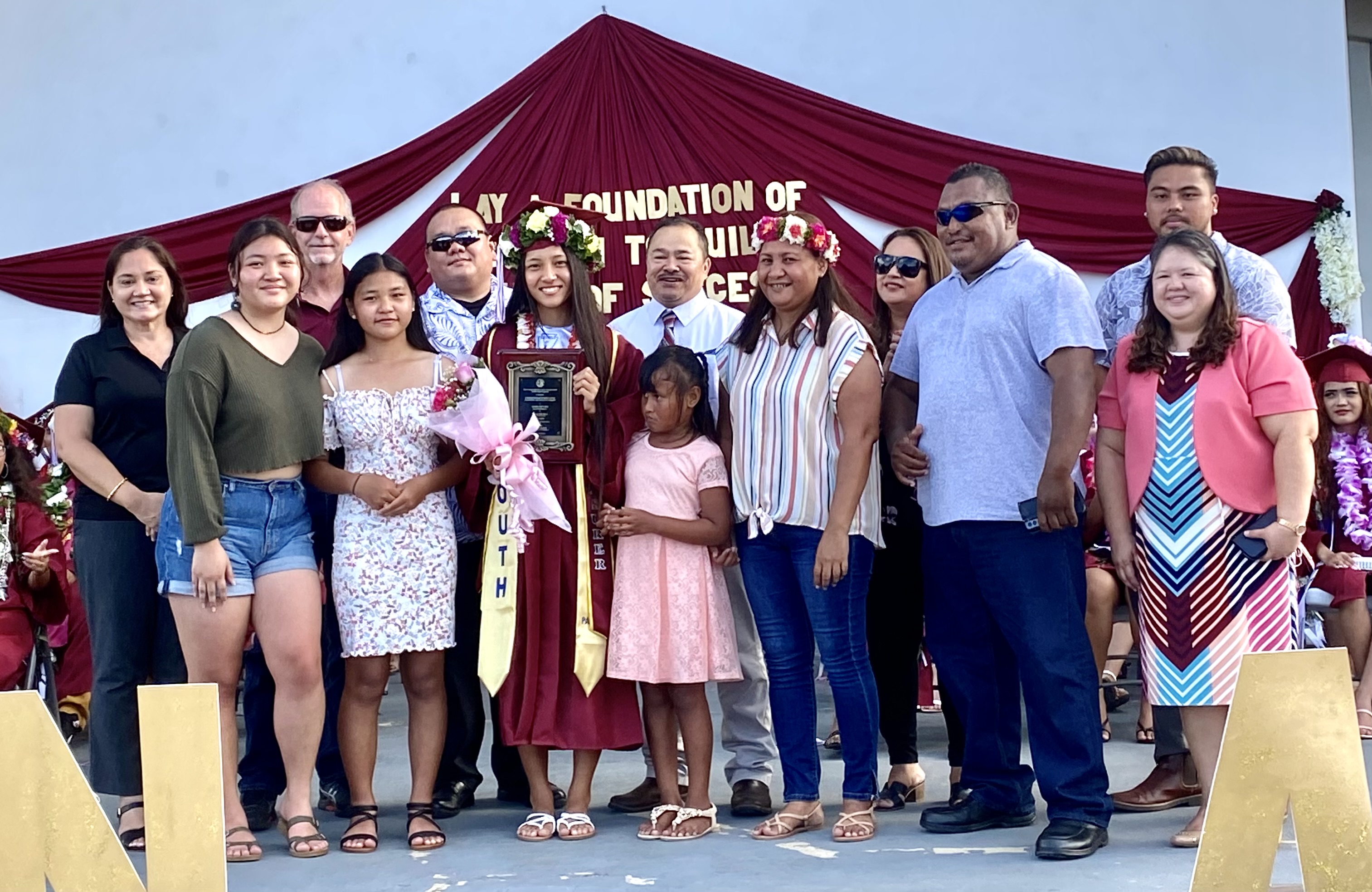 Dasol Erin Kim, Class of 2022 salutatorian and recipient of the Commissioner of Education Award, poses for a photo with her family  and Public School System officials led by Education Commissioner Dr. Alfred B. Ada.