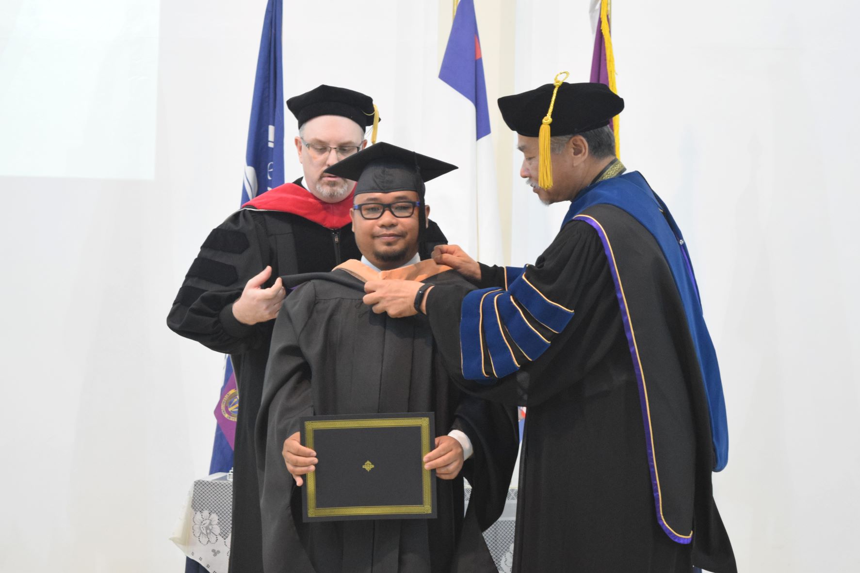 Masters of Business Administration graduate Rapture Tarlit with EUCON International University President/Administrator Dr. Christian Wei and Vice President Dr. Sean Sartler.