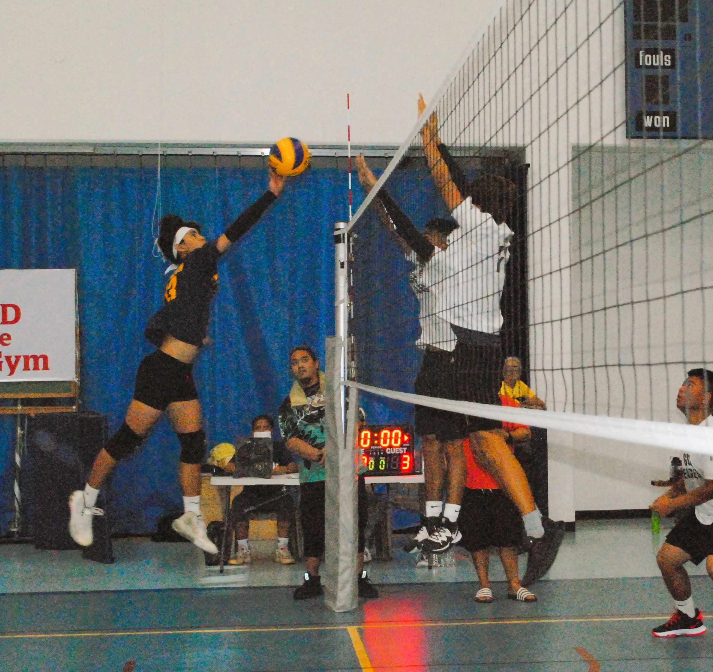 MHS' Jerome Manzon attempts to tip the ball over two defenders during the championship game of the PSS High School Boys Volleyball League on Saturday at  MHS gym.