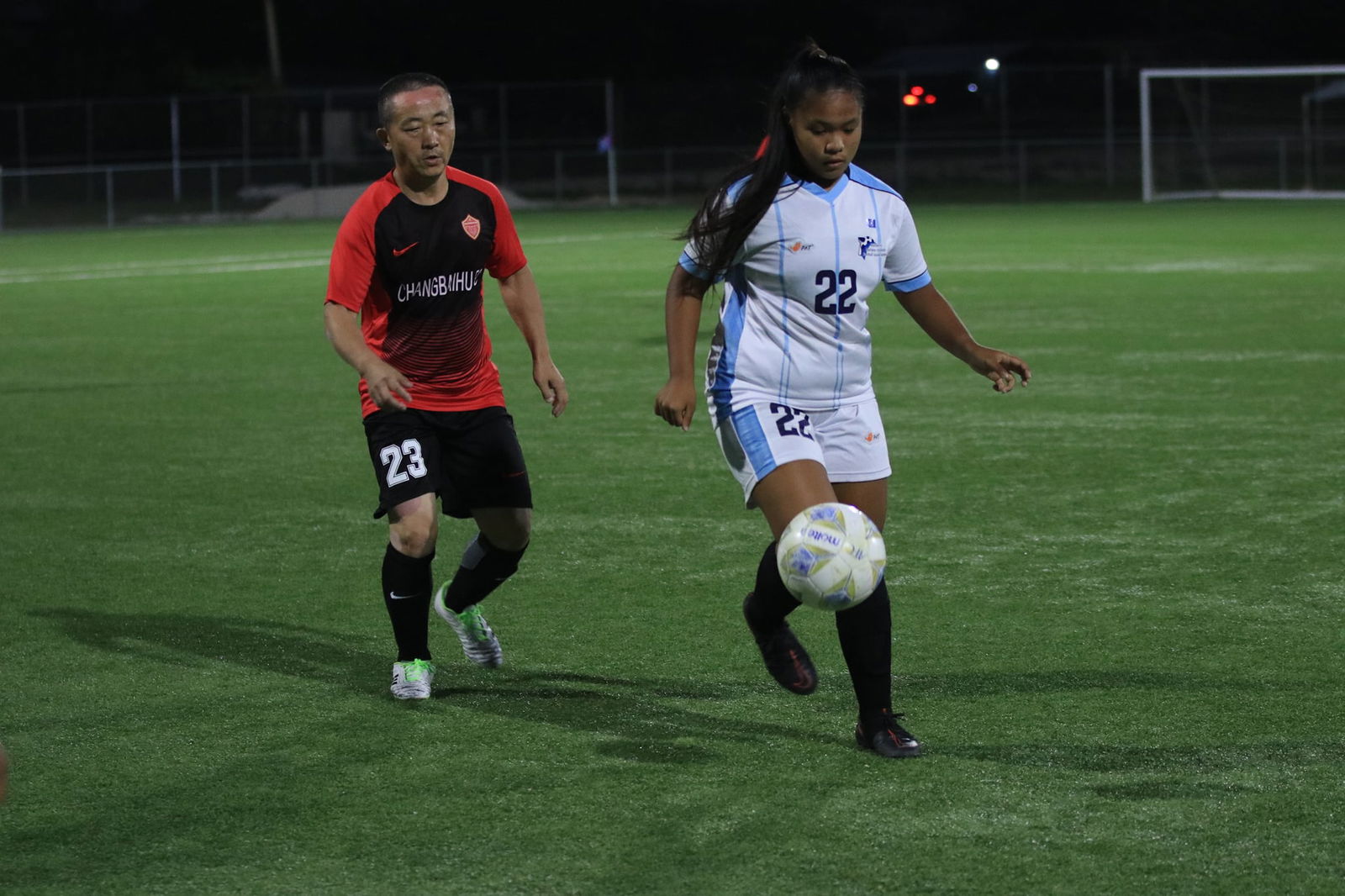 Women's DT's Rizza Relucio controls the possession as a defender closes in during a Men's Soccer League 2 game at the NMI Soccer Training Center.