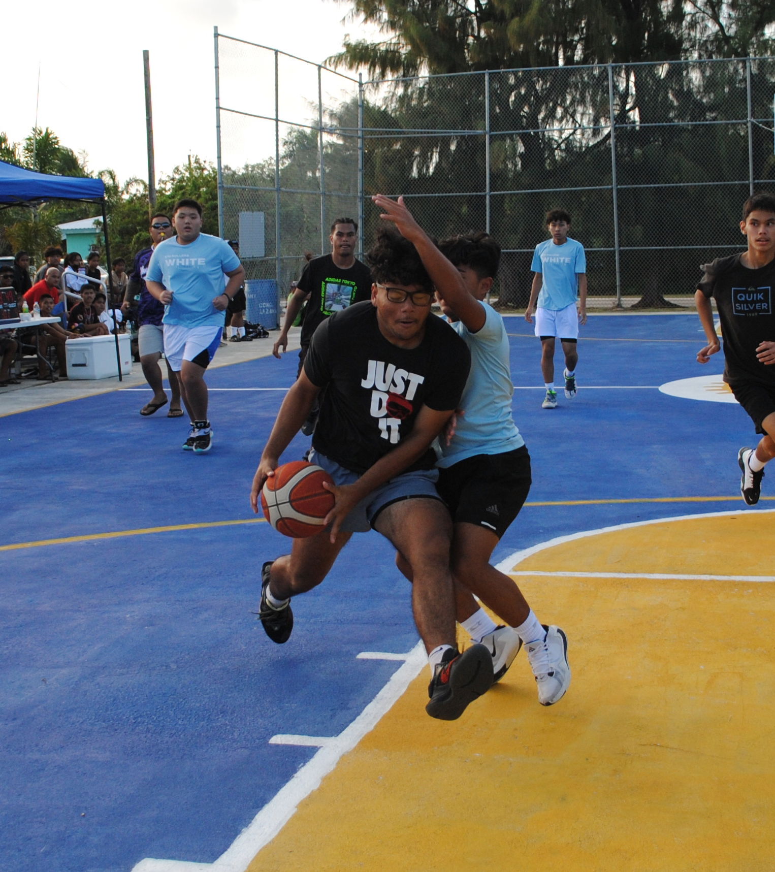 Boys AMP's Myles Techur protects the ball as he drives toward the hoop during a P5 Hoops & Vibes Basketball Tournament game  at the Kagman Community Center basketball court on Monday.